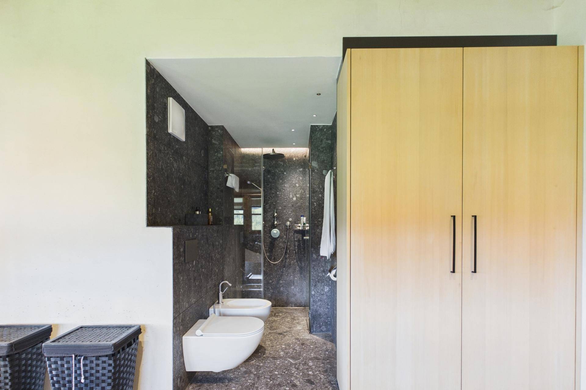 Modernes Badezimmer mit begehbarer Dusche, Bidet und stilvollen Armaturen.
