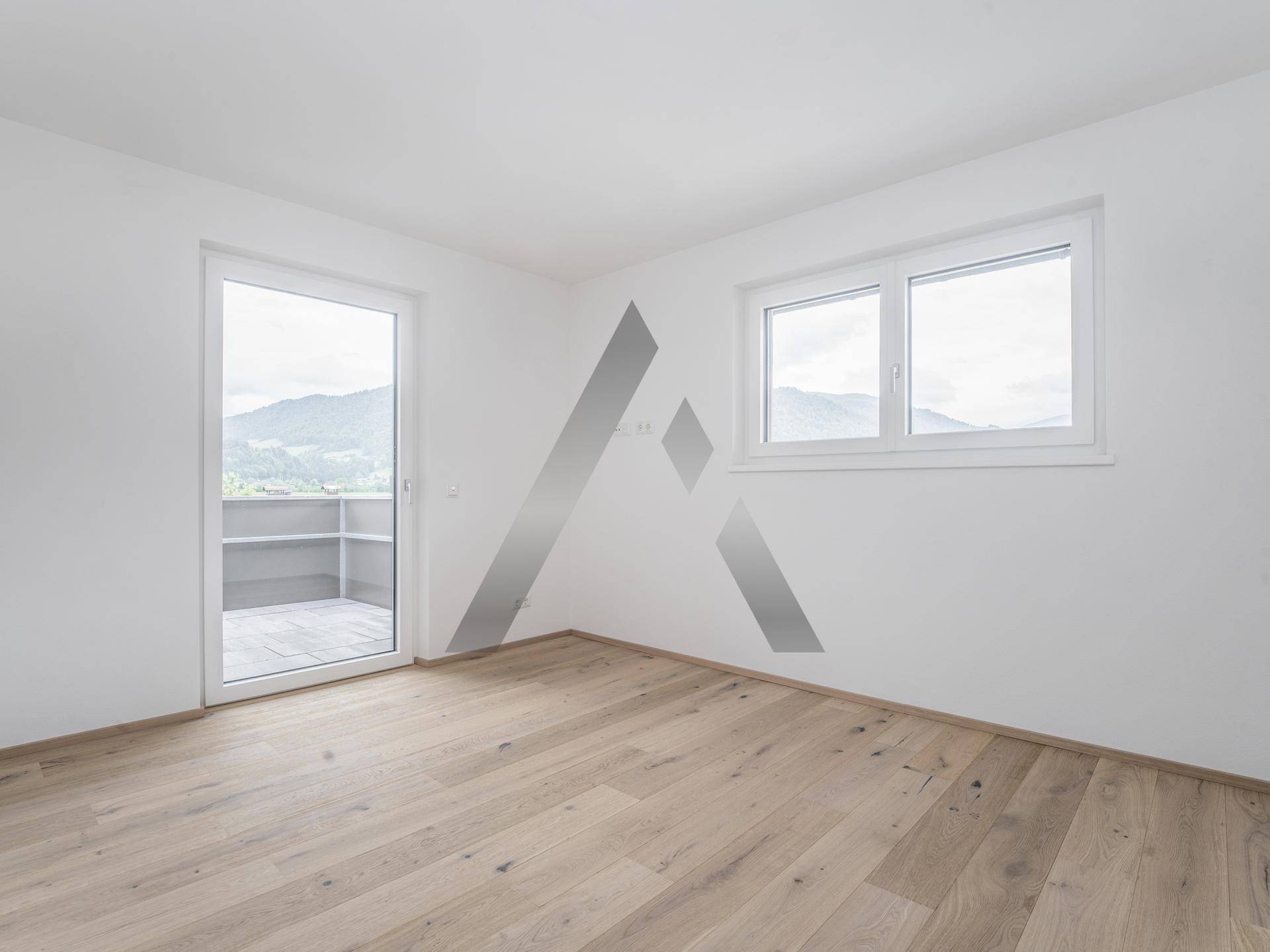 Schlafzimmer mit Holzboden und Zugang zu einem Balkon, bietet einen schönen Blick auf die Landschaft.