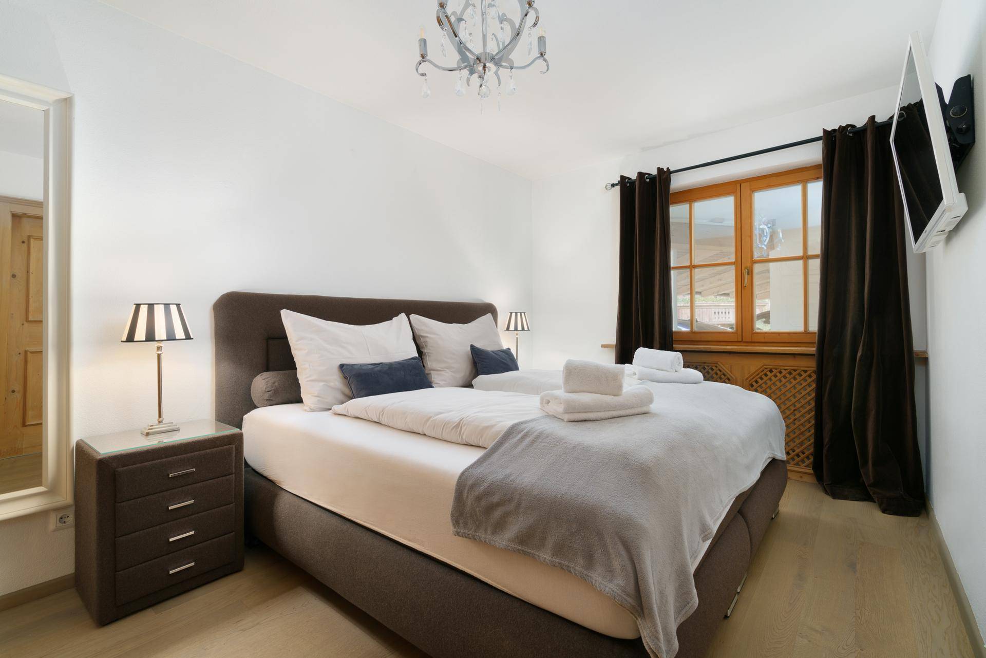 Gemütliches Schlafzimmer mit Doppelbett, Holzboden und Blick auf die Umgebung.