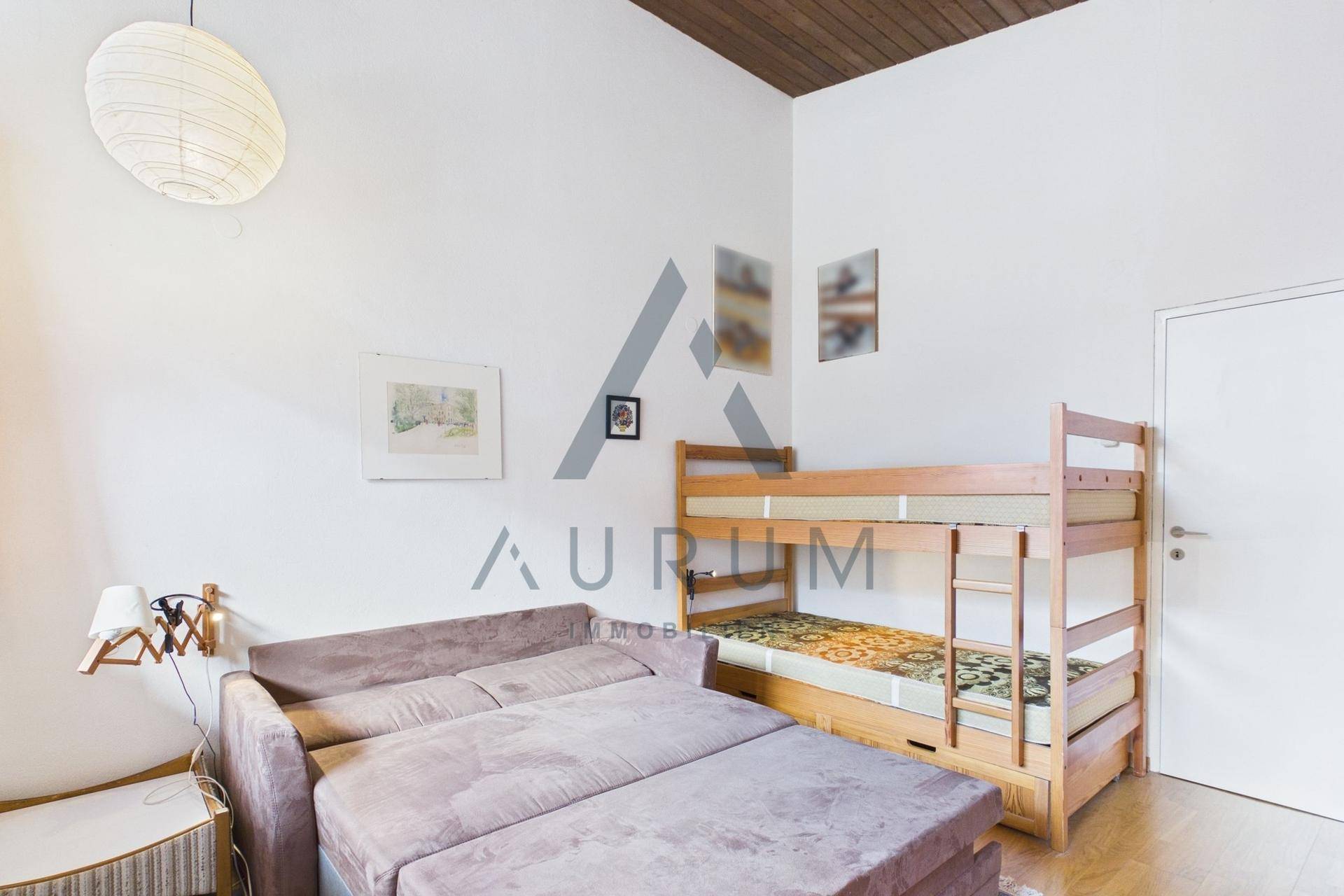 Gemütliches Schlafzimmer mit Etagenbett und Schlafsofa, ideal für Gäste oder Kinder.