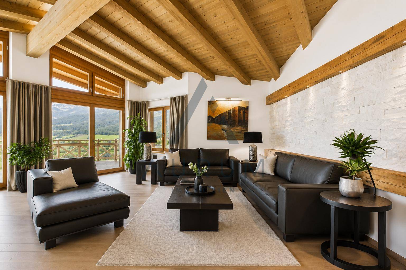 Helles Wohnzimmer mit hohen Holzdecken, bequemen Ledersofas und großen Fenstern mit Bergblick.