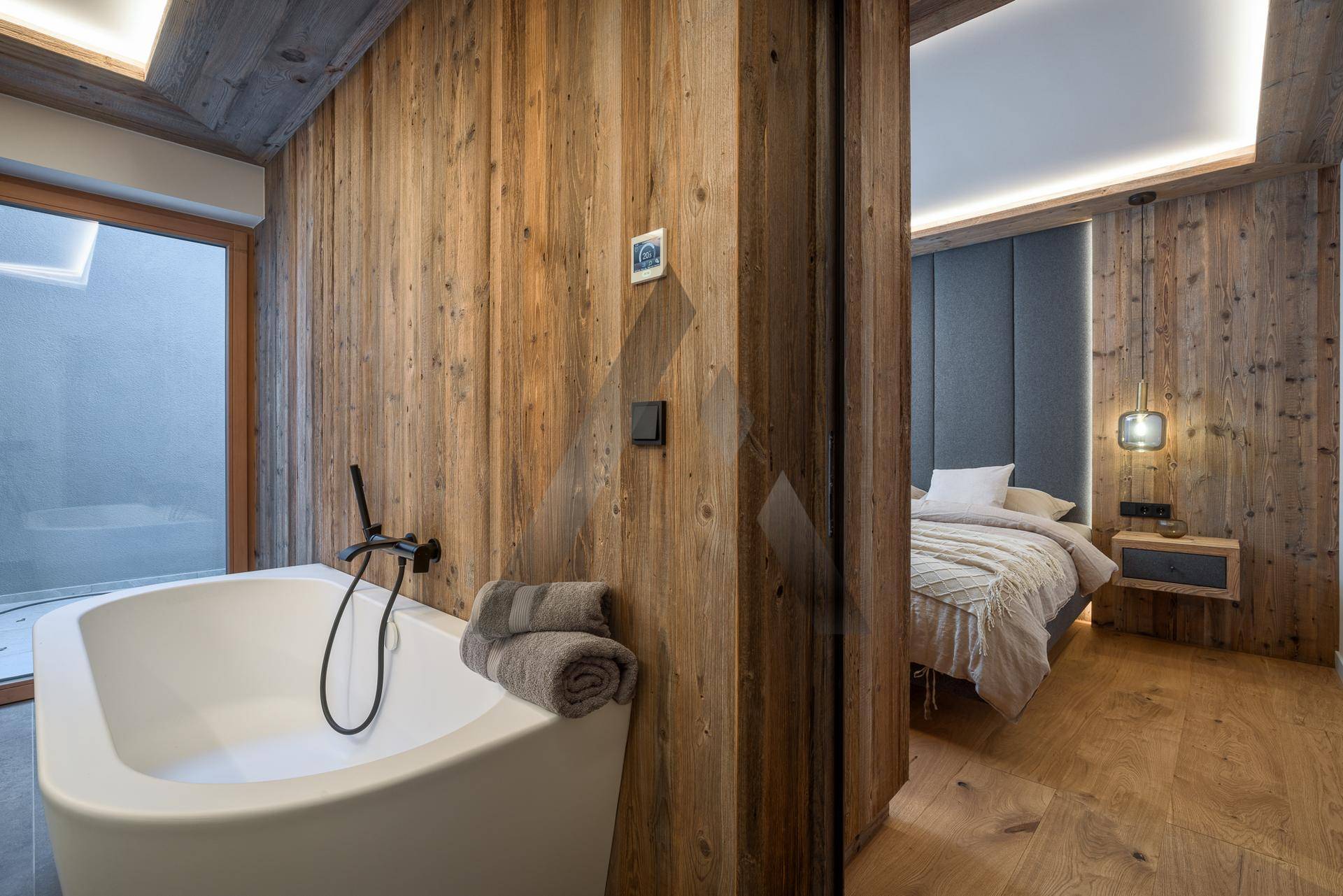 Elegantes Badezimmer mit freistehender Badewanne und direktem Zugang zum Schlafzimmer.