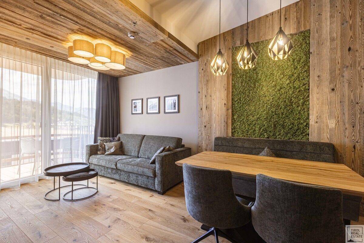 Gemütlicher Wohn-Essbereich mit Holzboden, Holzwänden und einer dekorativen Mooswand.