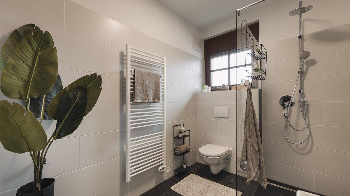 Helles Badezimmer mit begehbarer Dusche, Fenster und modernem Waschtisch.
