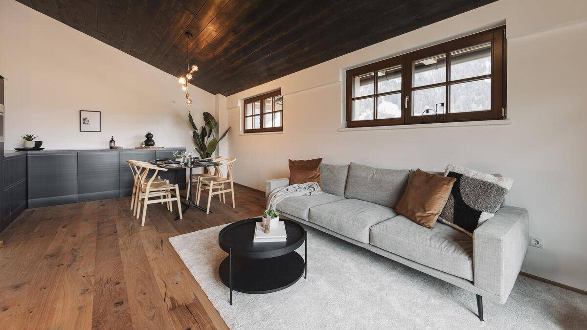 Geräumiger Wohn- und Essbereich mit Holzboden, Teppich und moderner Einrichtung.