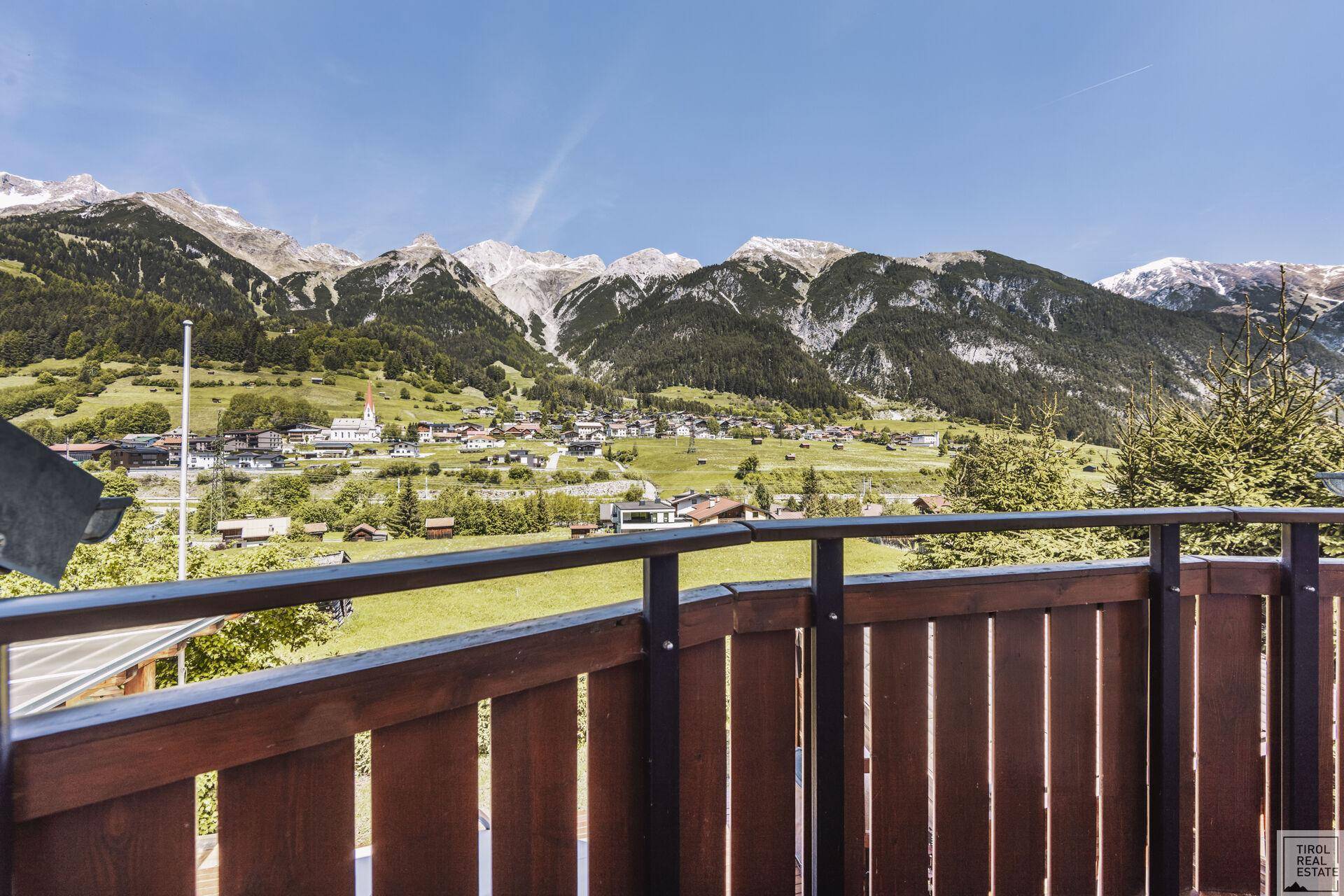 Balkon mit Panoramablick auf die majestätischen Berge und ein idyllisches Dorf.