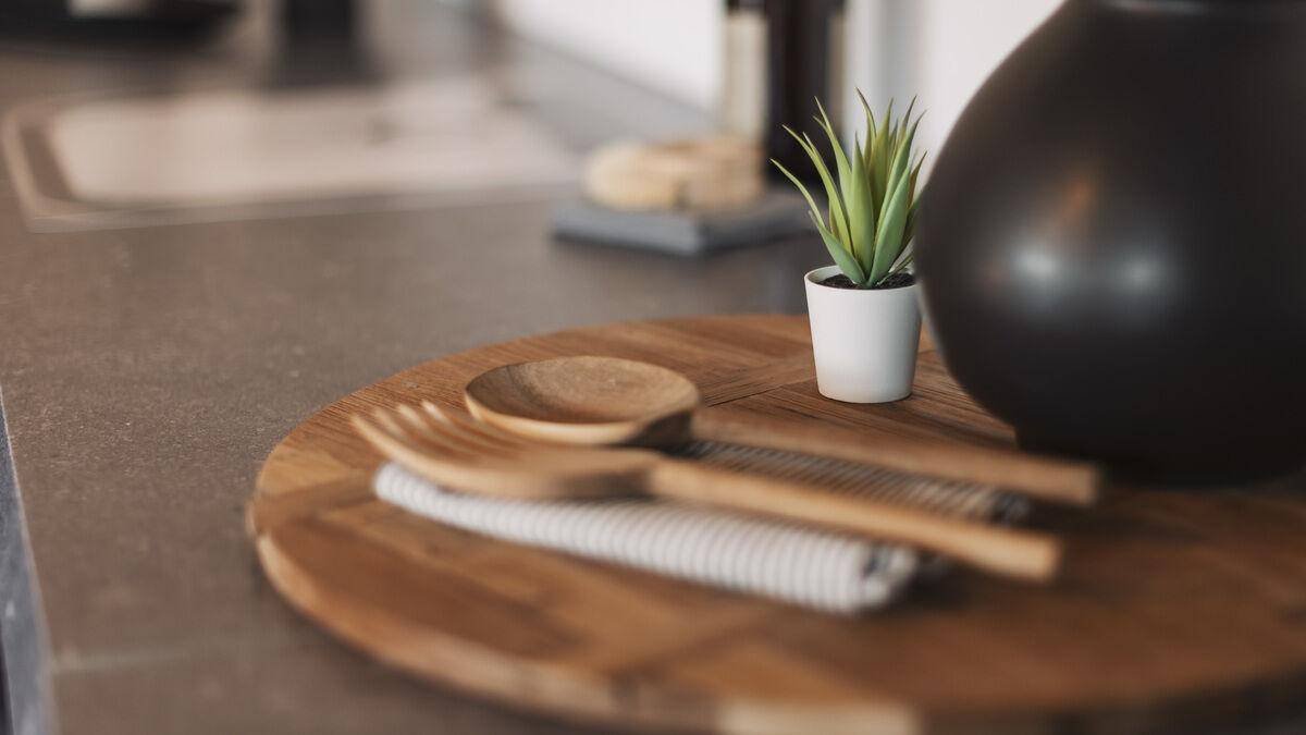Detailansicht einer Küchenarbeitsplatte mit Holzbrett und kleiner Pflanze.