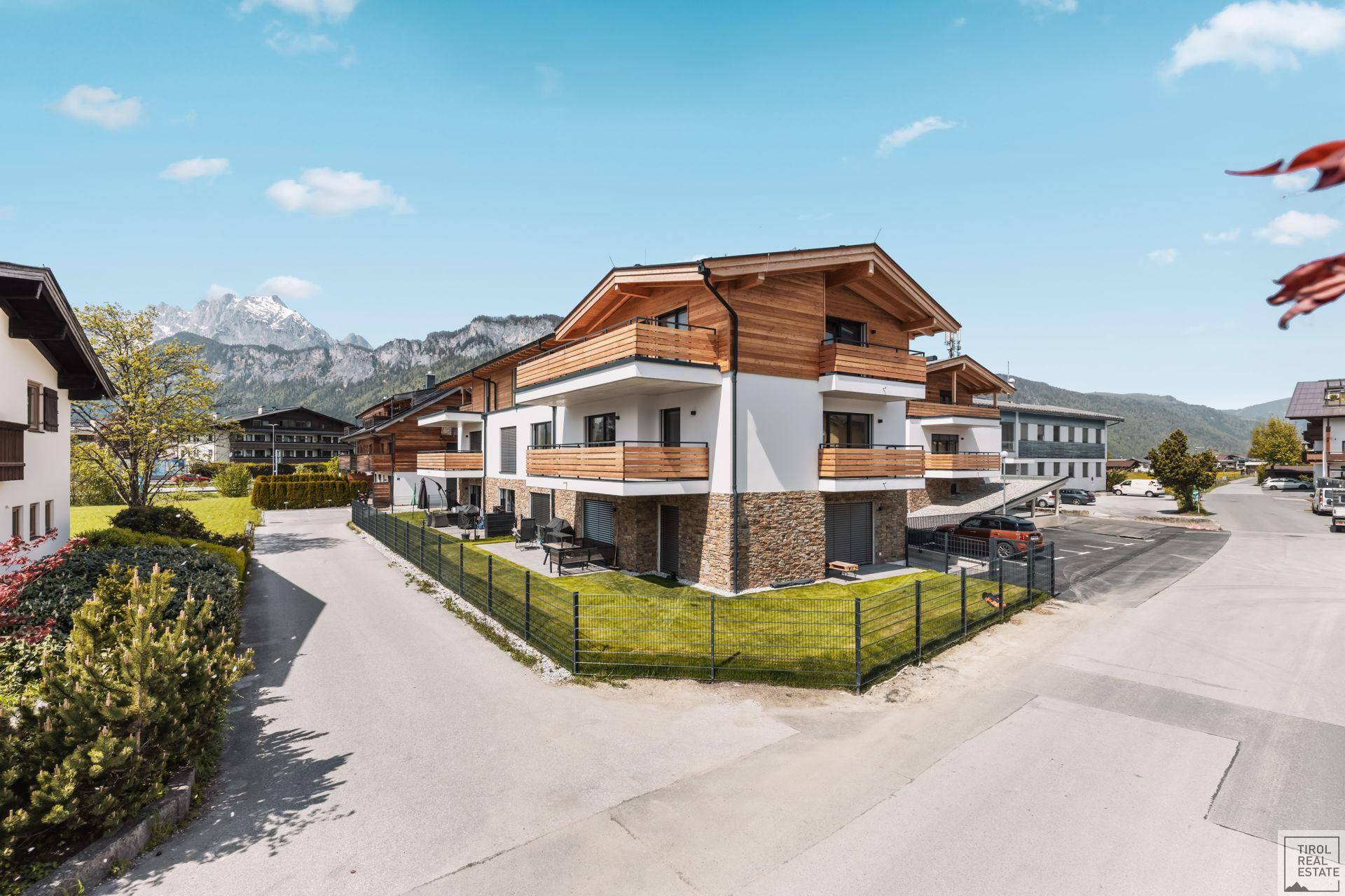 Neubau-Wohnanlage mit Holzelementen und Bergblick in einer ländlichen Umgebung.