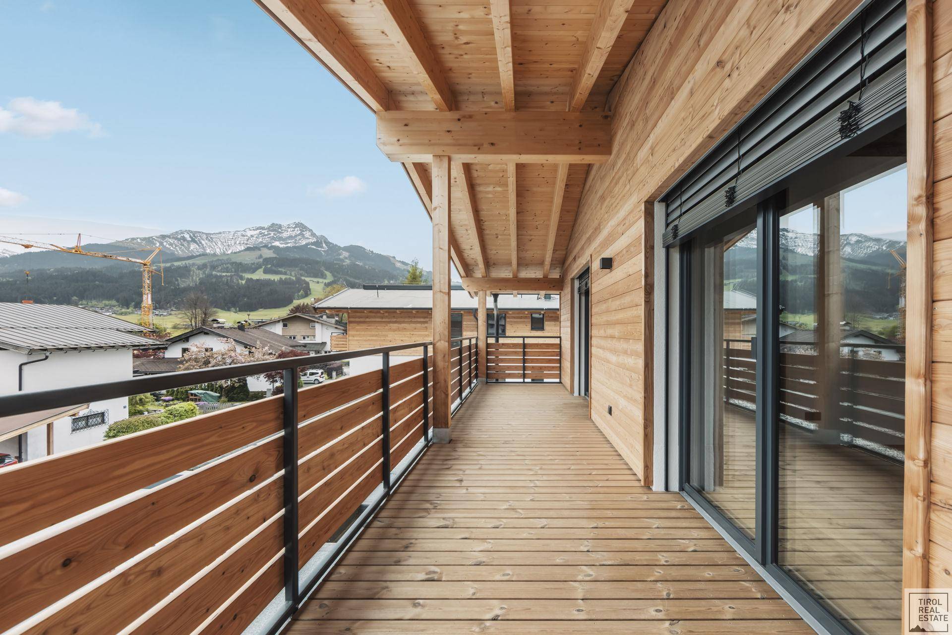 Langer Holzbalkon mit Bergblick und moderner Holzverkleidung, ideal für frische Luft.