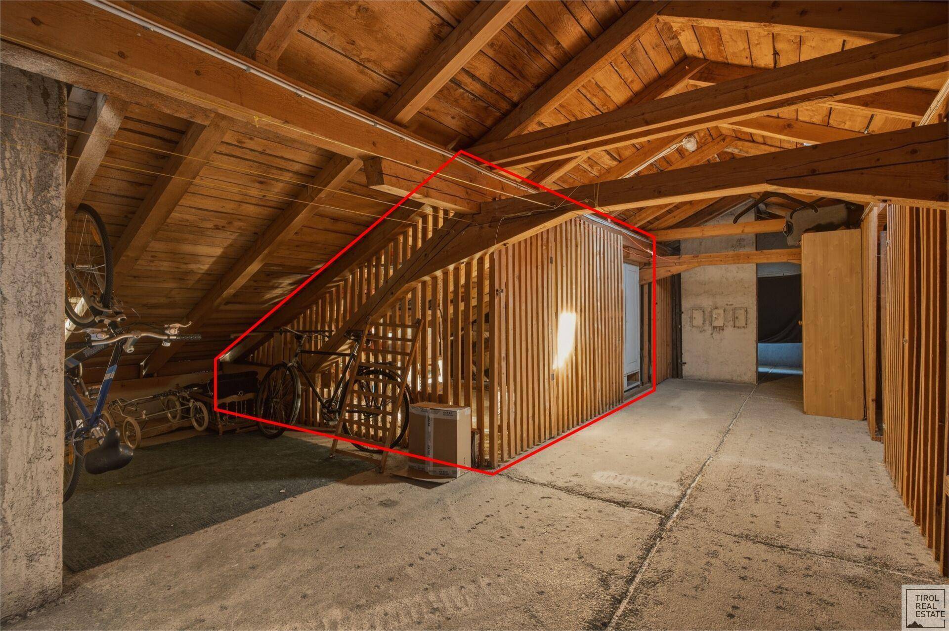 Geräumiger Dachboden mit sichtbaren Holzbalken und Stauraum für Fahrräder.