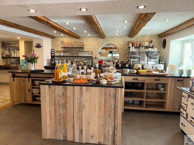 Ansprechender Frühstücksbereich mit Buffet, Holzelementen und freiliegenden Deckenbalken.