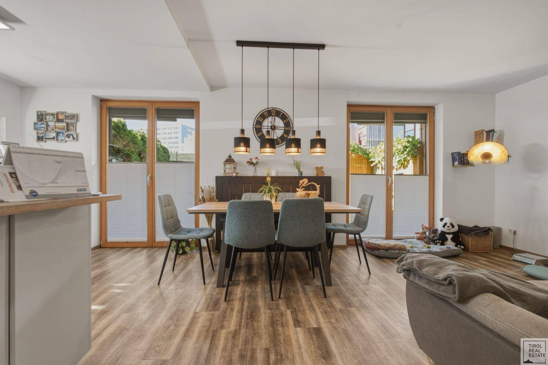 Essbereich mit Holztisch und Stühlen, umgeben von großen Fenstern für viel Tageslicht.