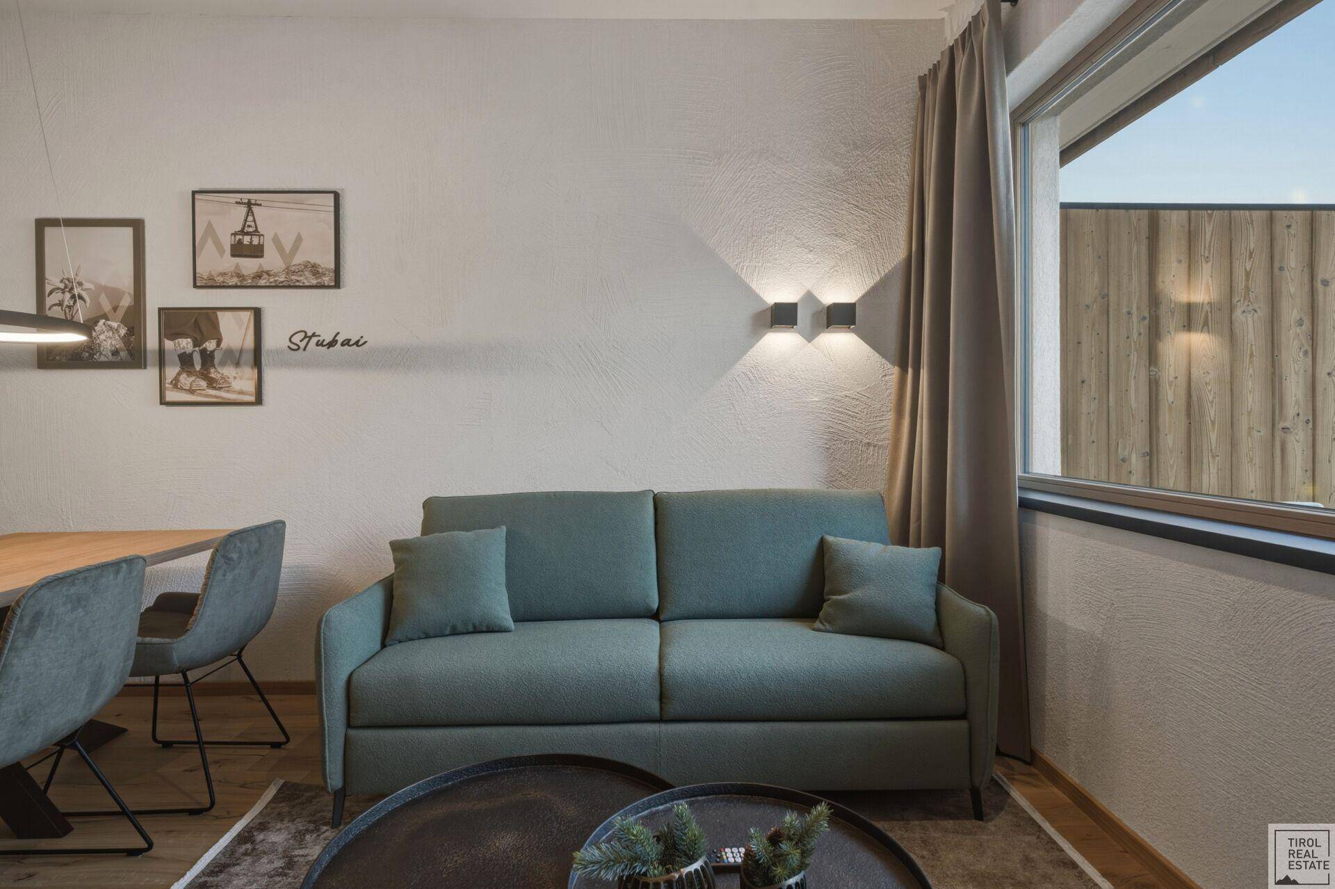 Gemütliches Wohnzimmer mit Sofa und Blick auf die umliegende Berglandschaft.