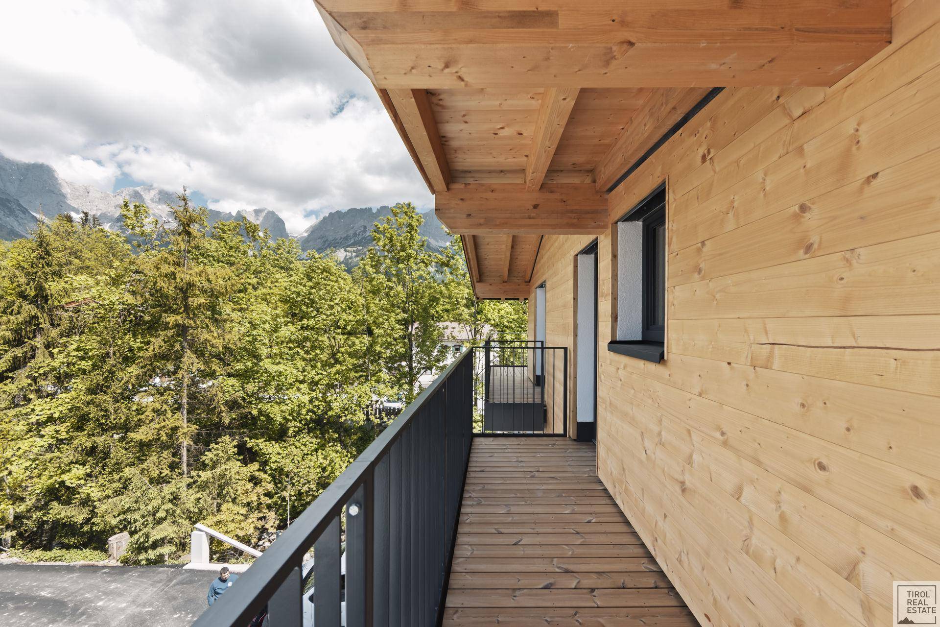 Überdachter Holzbalkon mit Blick auf die bewaldeten Berge und die Umgebung.