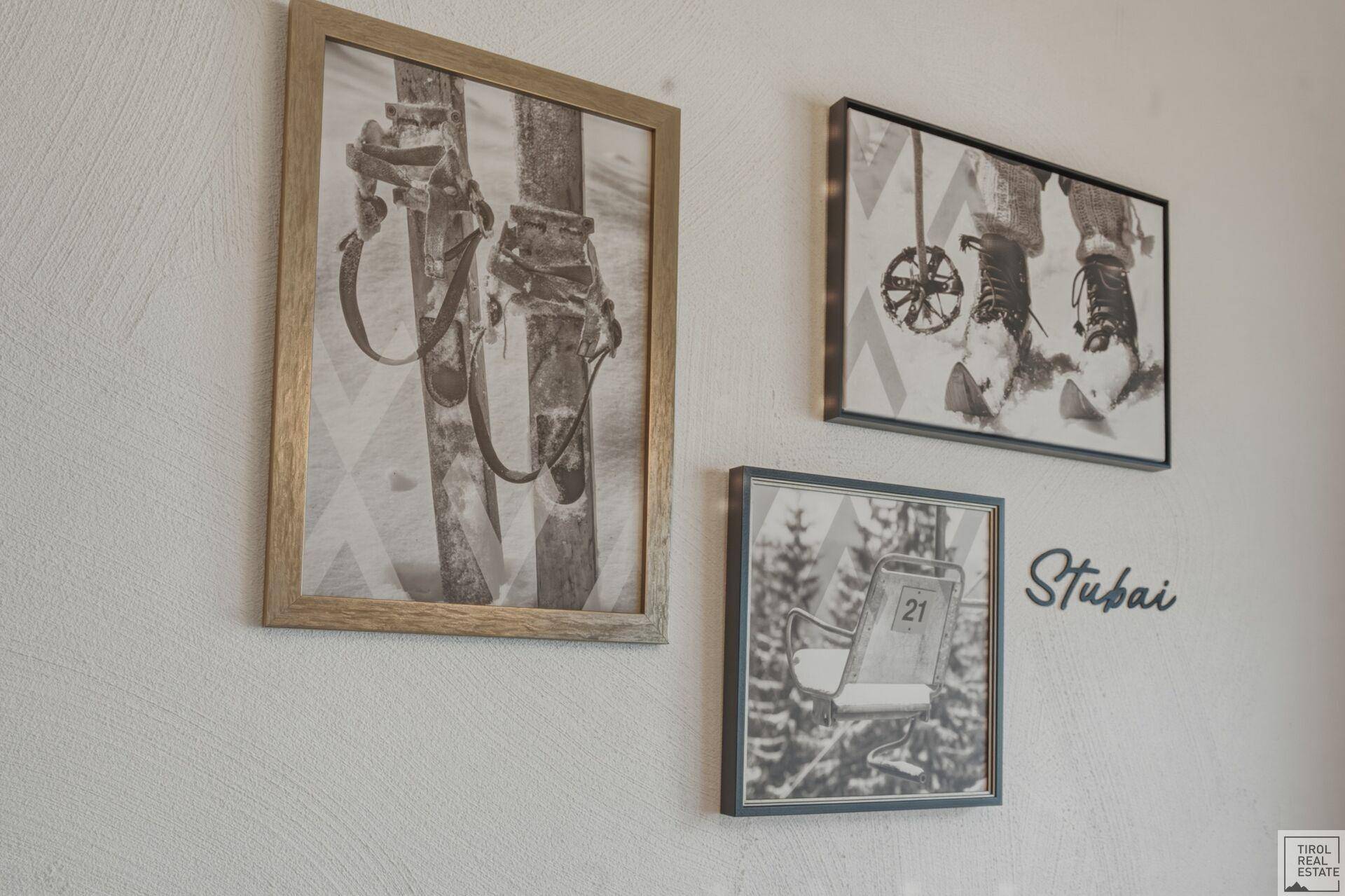 Wanddekoration mit gerahmten Schwarz-Weiß-Bildern zum Thema Skifahren und "Stubai"-Schriftzug.