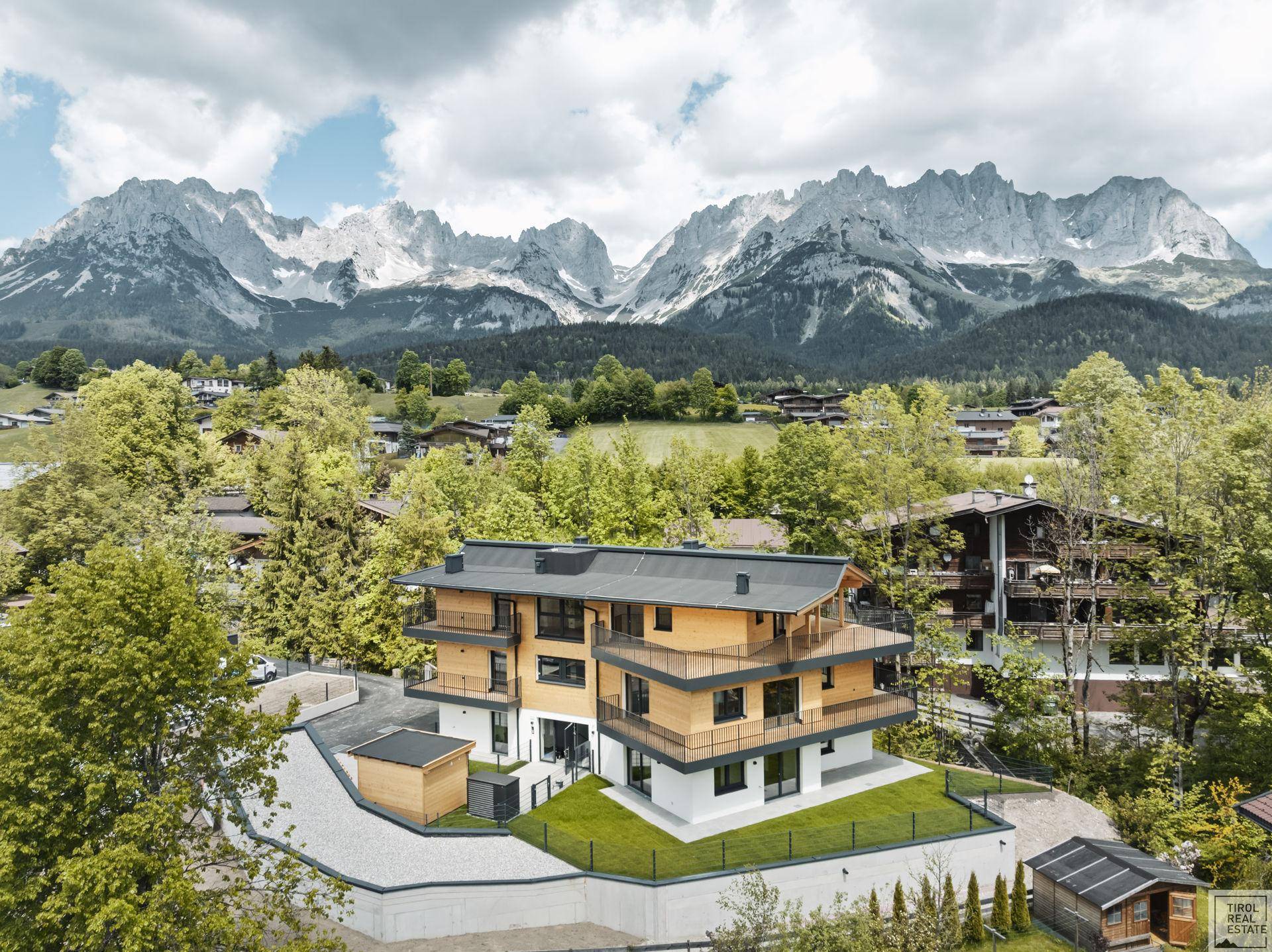 Neubau-Wohnhaus in Holzbauweise mit gepflegter Grünfläche und majestätischem Bergblick.