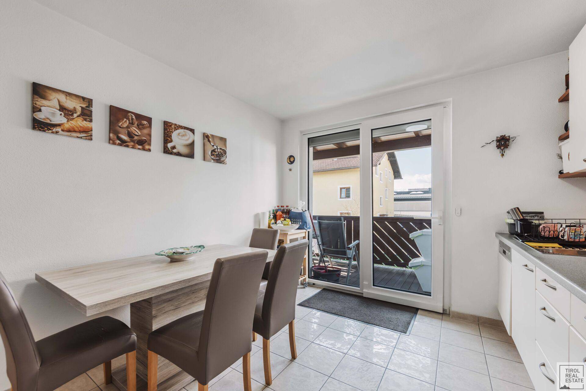 Helle Essküche mit modernem Esstisch und direktem Zugang zum Balkon.