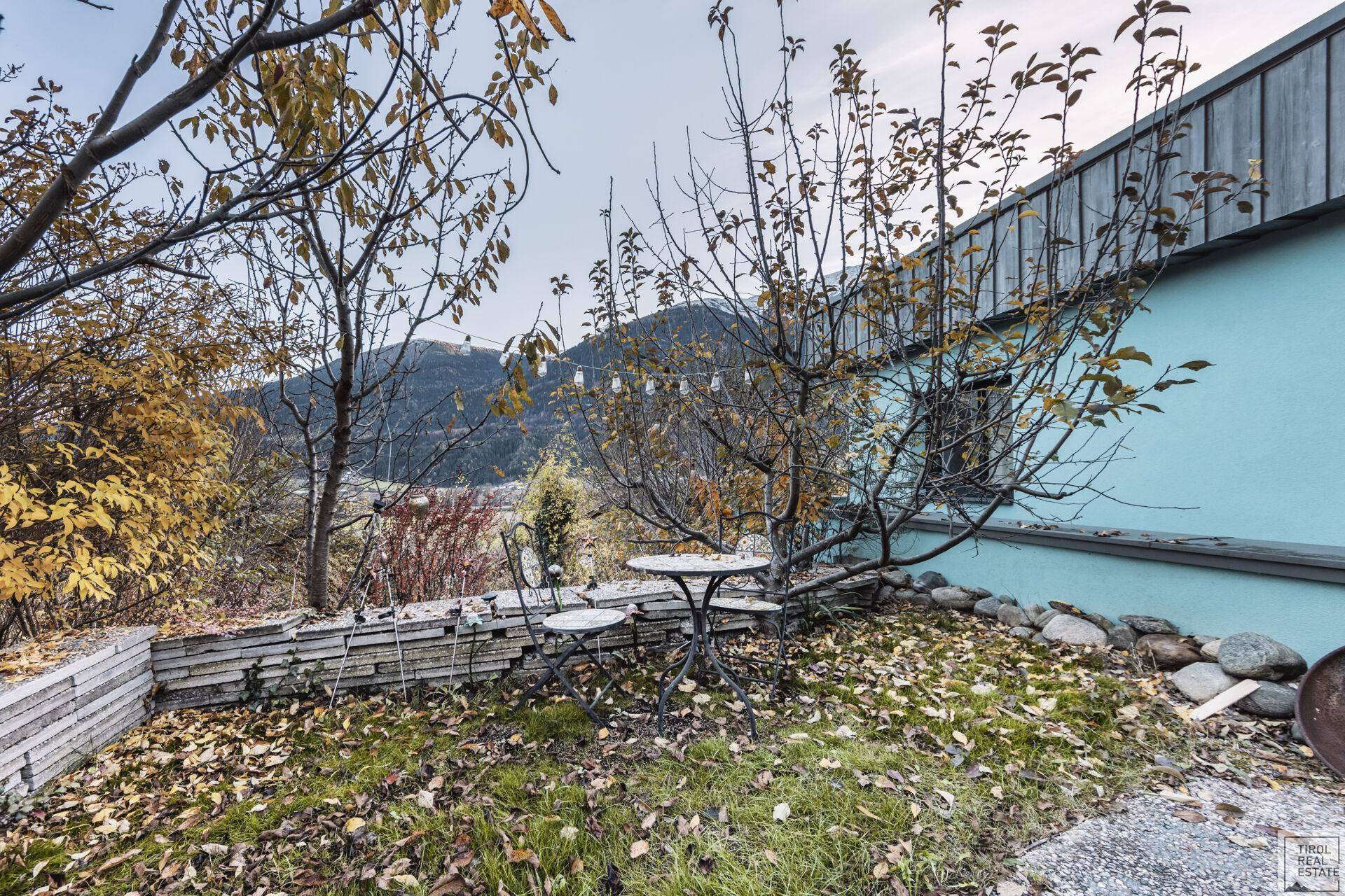 Kleiner Gartenbereich mit Sitzgelegenheiten und Blick auf die umliegende Natur.