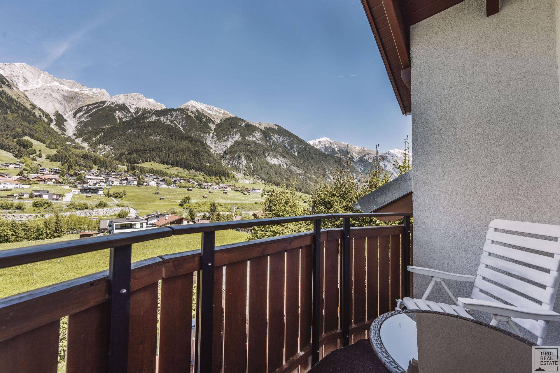 Geräumiger Balkon mit Holzboden und atemberaubendem Blick auf die umliegende Berglandschaft.