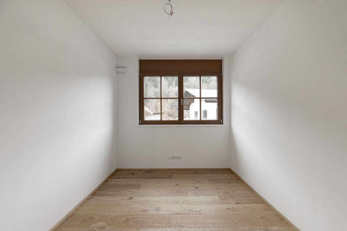 Kleiner, heller Raum mit Eichenparkett und Fenster, ideal als Schlaf- oder Arbeitszimmer.