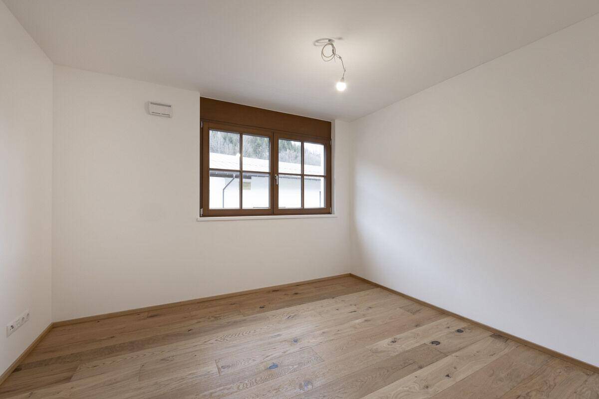 Gemütlicher Raum mit Eichenparkett und Fenster, bietet eine ruhige Atmosphäre.