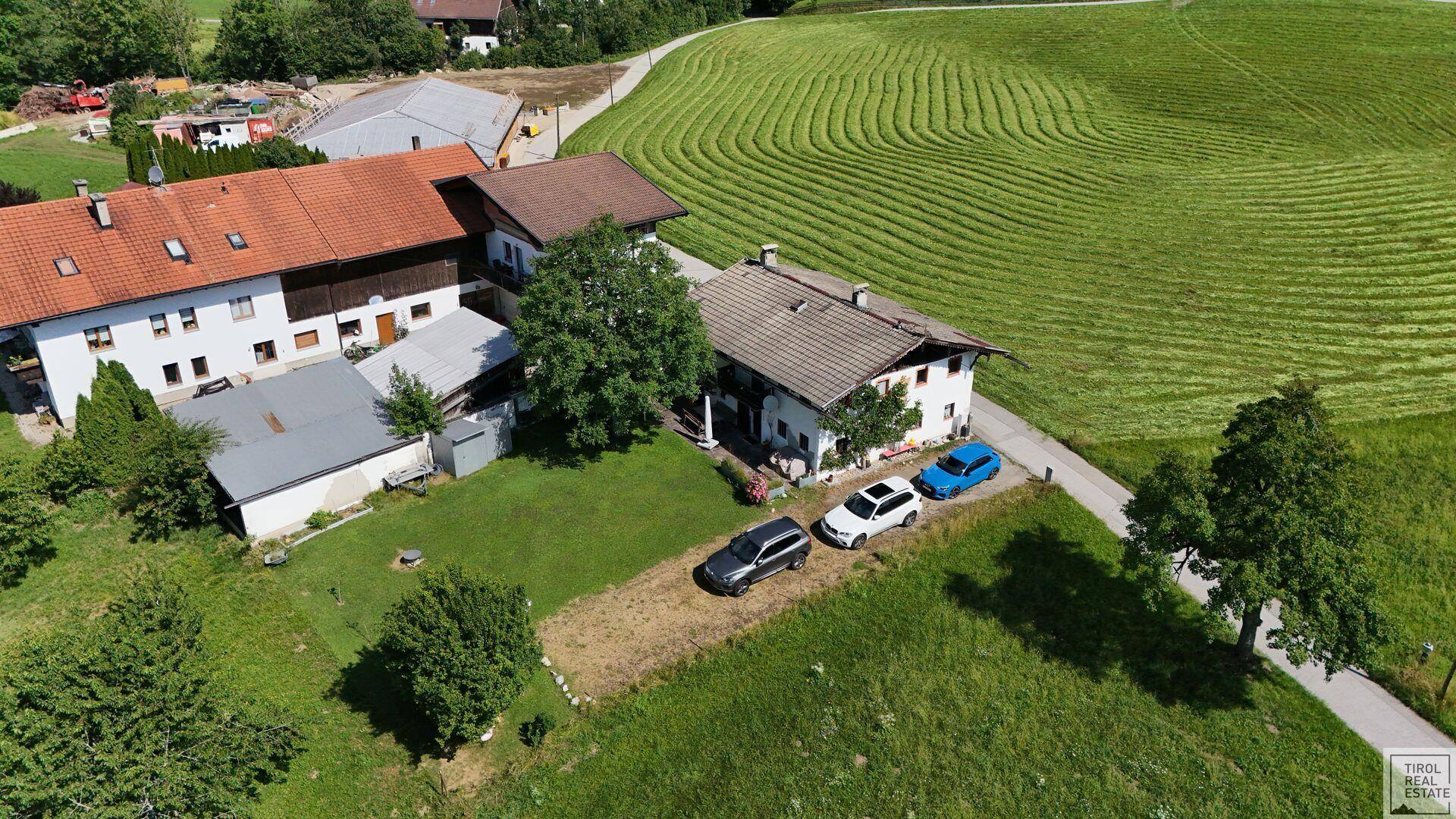 Weitläufige Luftaufnahme des Anwesens inmitten grüner Hügellandschaft.