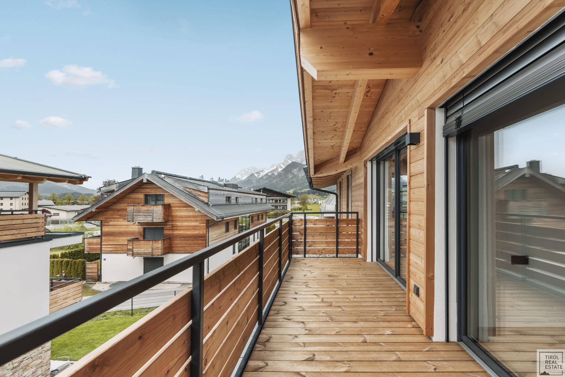 Langer Holzbalkon mit Bergblick und moderner Holzverkleidung, ideal für frische Luft.