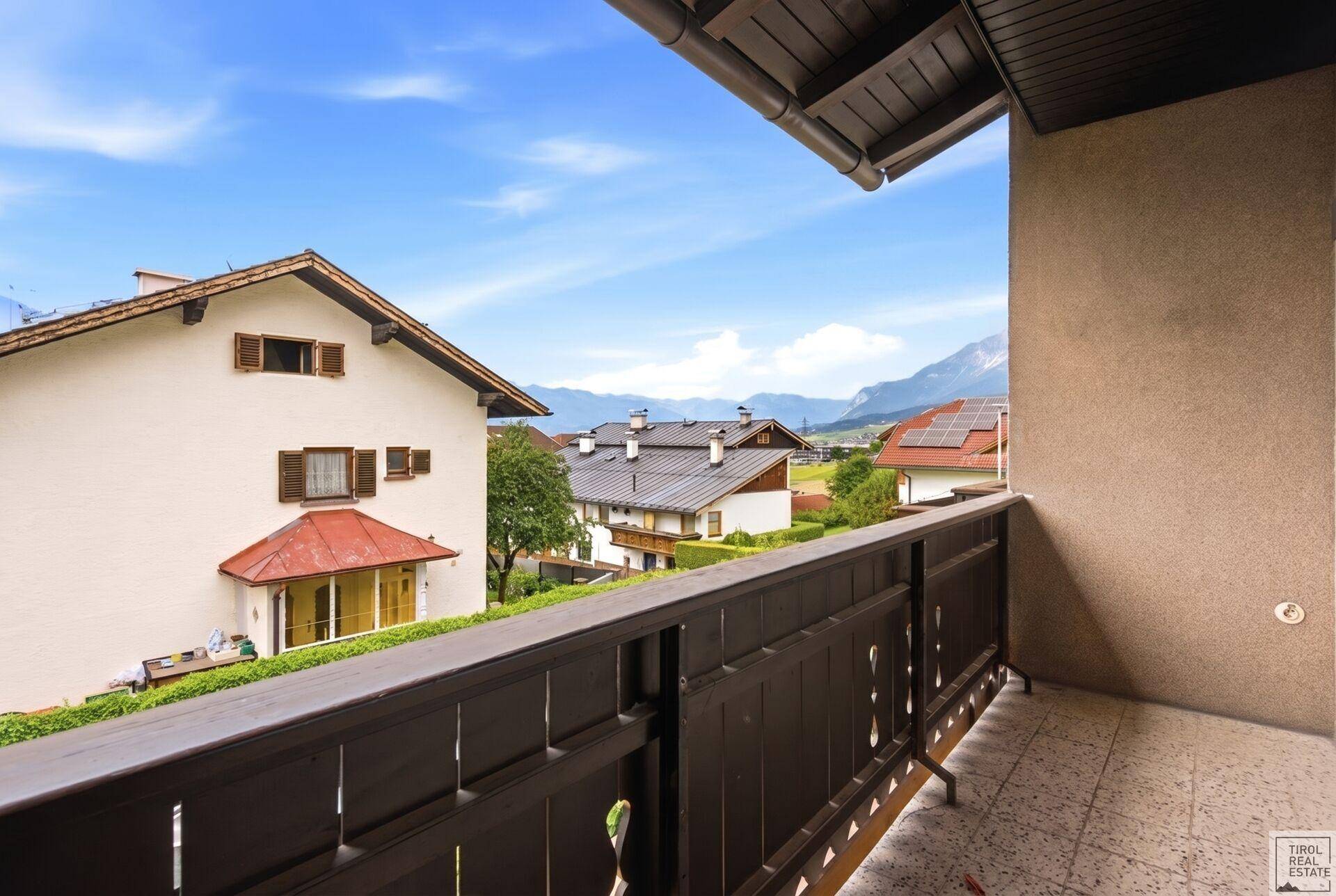Balkon mit traditionellem Geländer und weitem Blick auf die umliegende Berglandschaft.