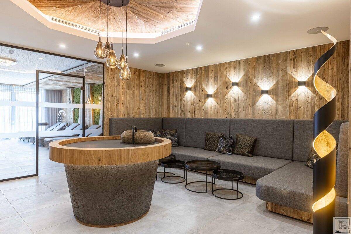 Moderner Wellnessbereich mit gemütlicher Sitzecke, Holzelementen und indirekter Beleuchtung.