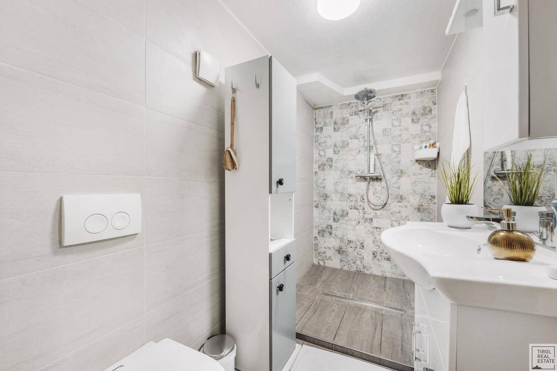 Modernes Badezimmer mit begehbarer Dusche, WC und Waschbecken.