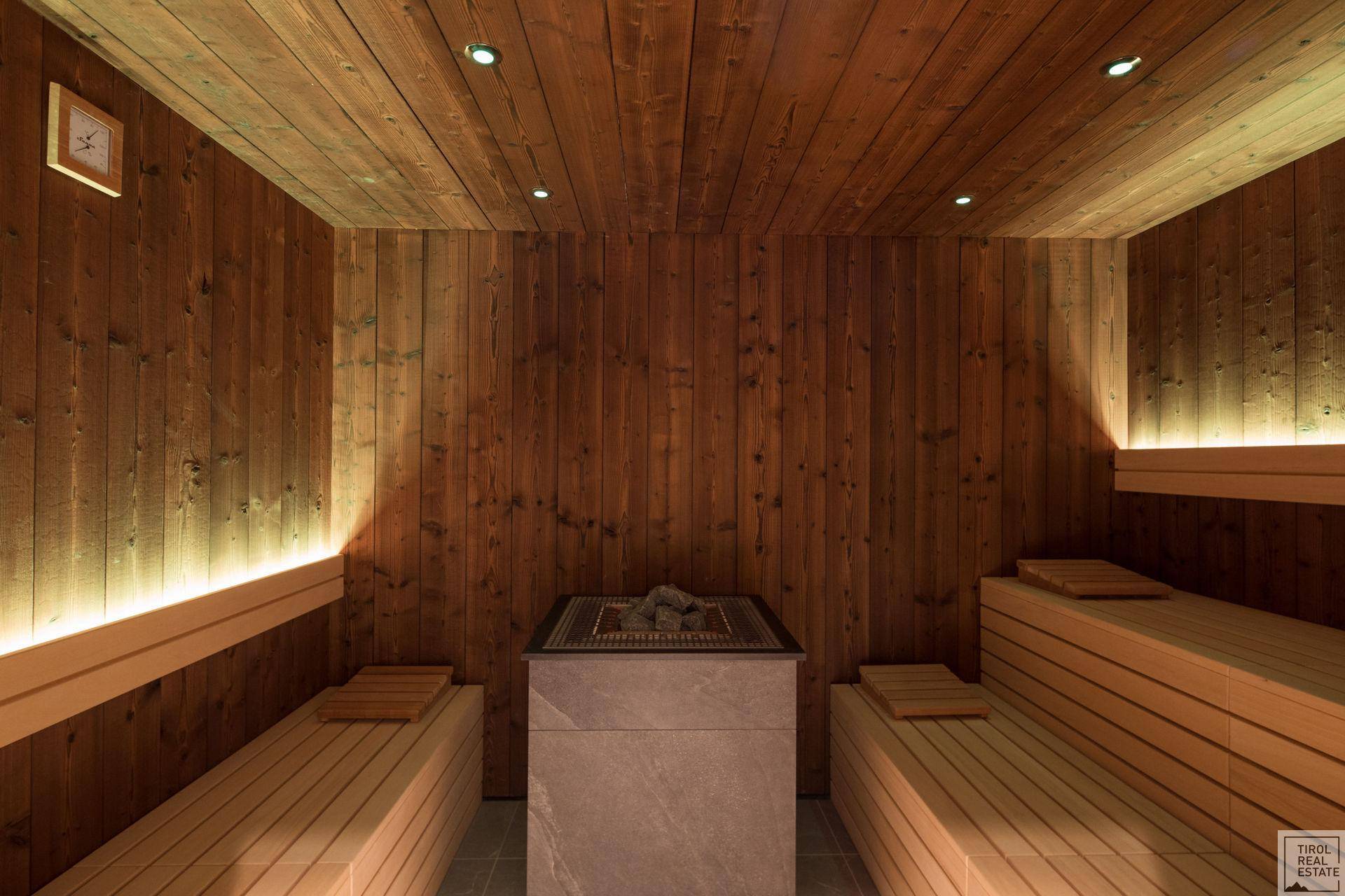 Traditionelle Holzsauna mit Bänken und Saunaofen, perfekt zur Entspannung und Erholung.