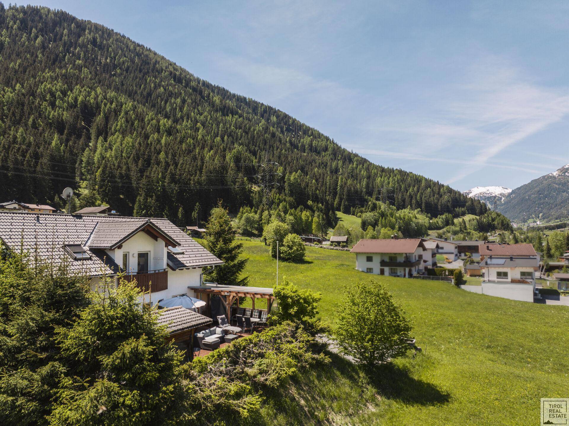 Weitläufige Ansicht des Hauses in einer grünen Hügellandschaft mit Bergblick.