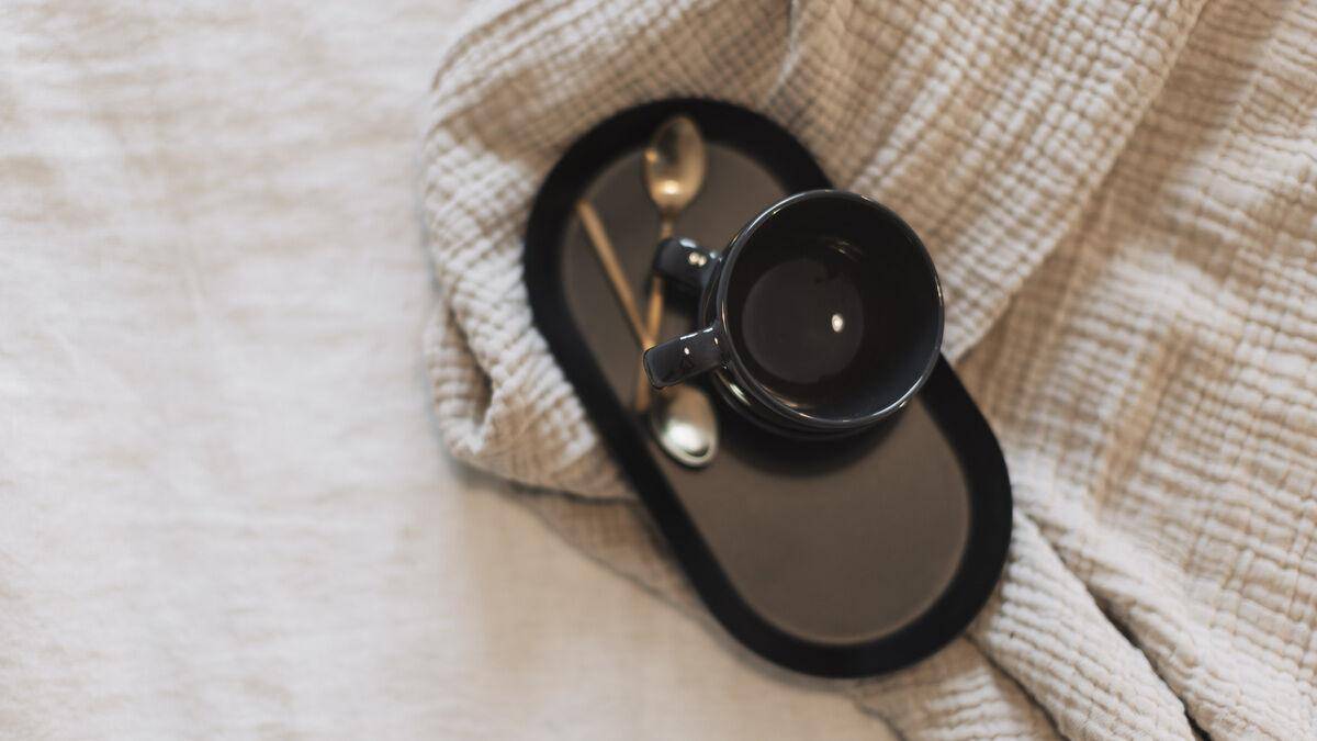 Detailansicht einer Tasse auf einem Tablett auf dem Bett.