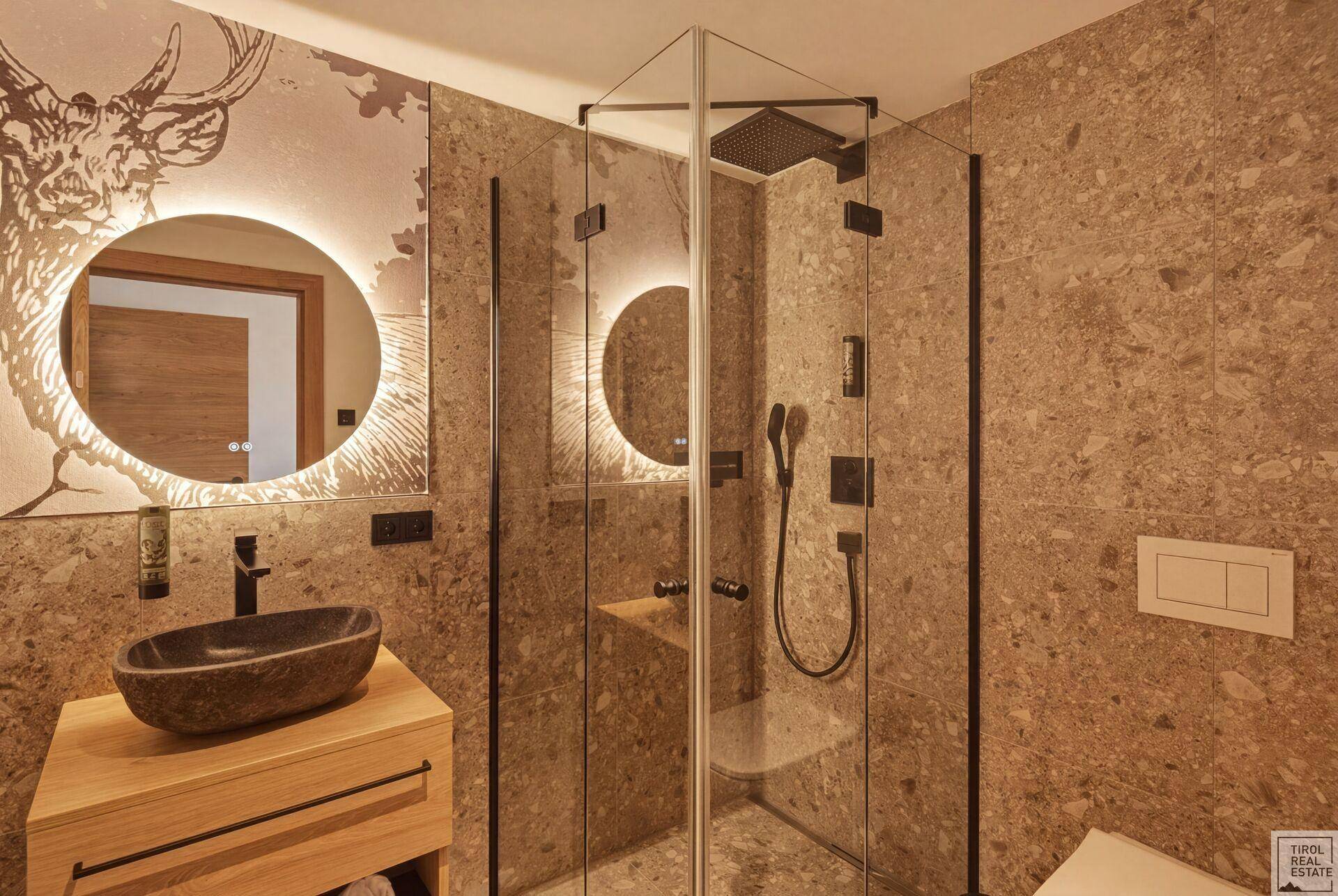 Geräumiges Badezimmer mit begehbarer Glasdusche und modernem Waschtischbereich.