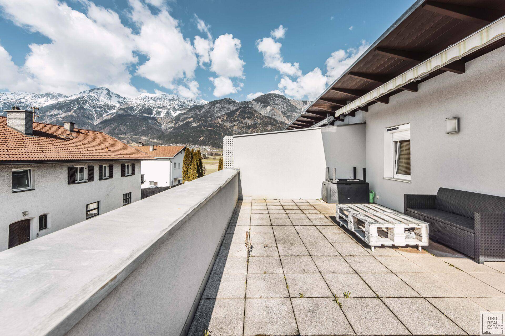 Weitläufige Dachterrasse mit Panoramablick auf die umliegenden Berge und Dächer.