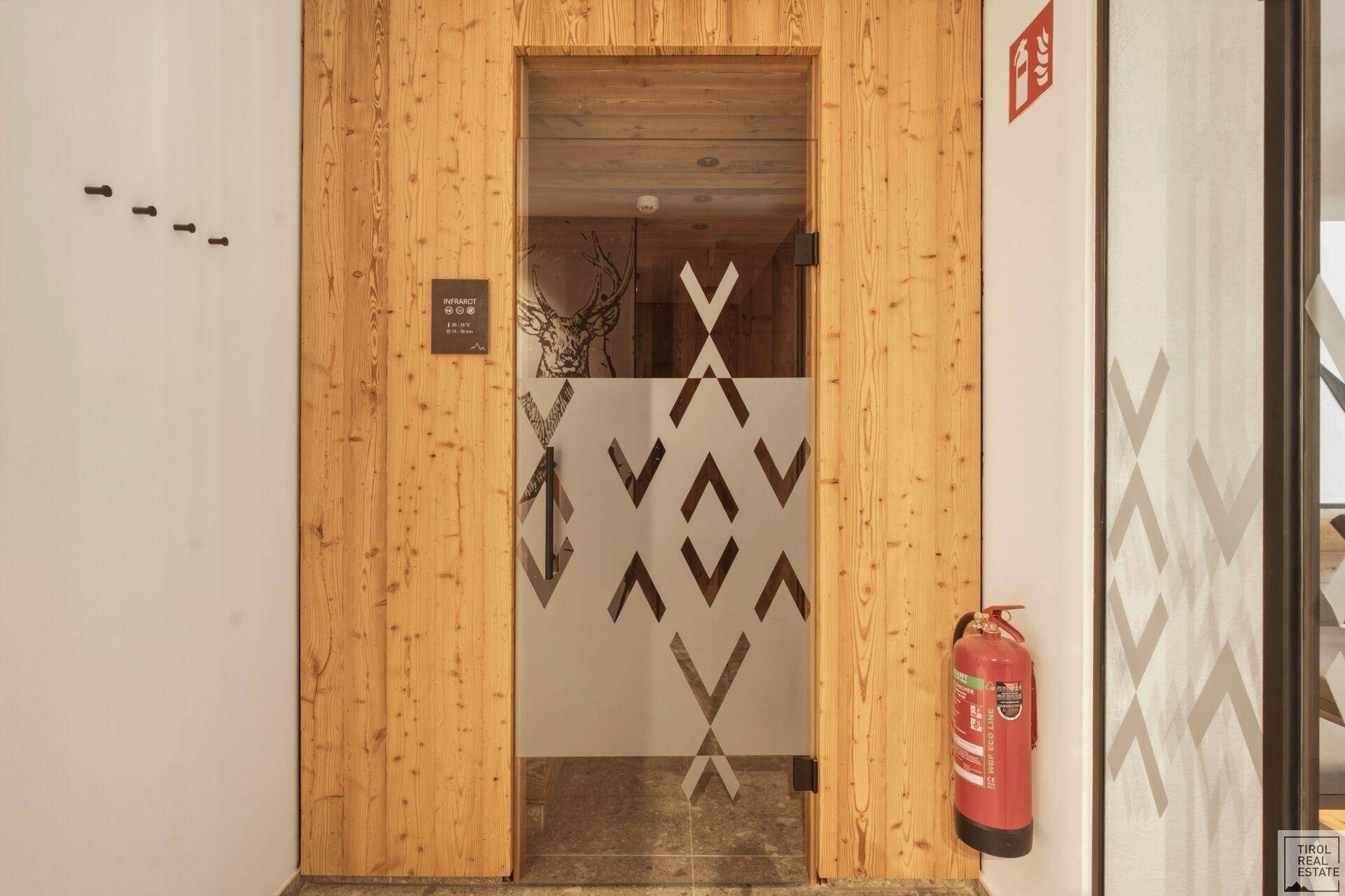 Eingang zur Sauna im Wellnessbereich mit Holztür und Glasdetails.