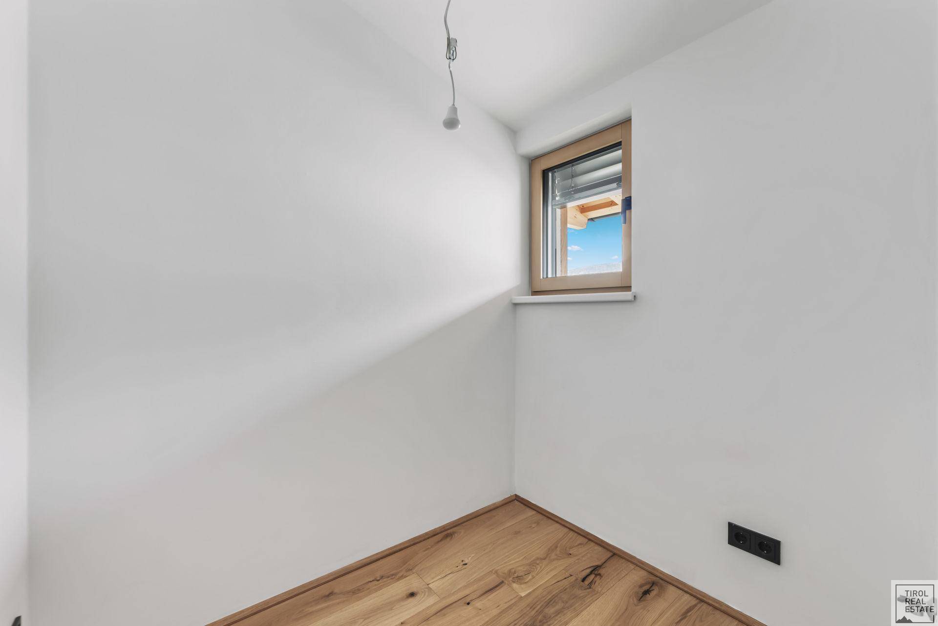 Kleines, helles Zimmer mit Parkettboden und Fenster, ideal als Kinder- oder Gästezimmer.