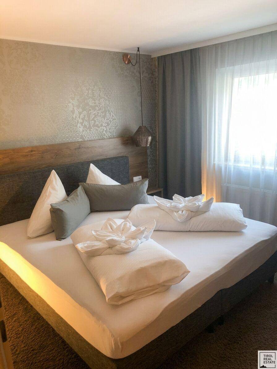 Komfortables Schlafzimmer mit Doppelbett, Holzkopfteil und weichem Teppichboden.