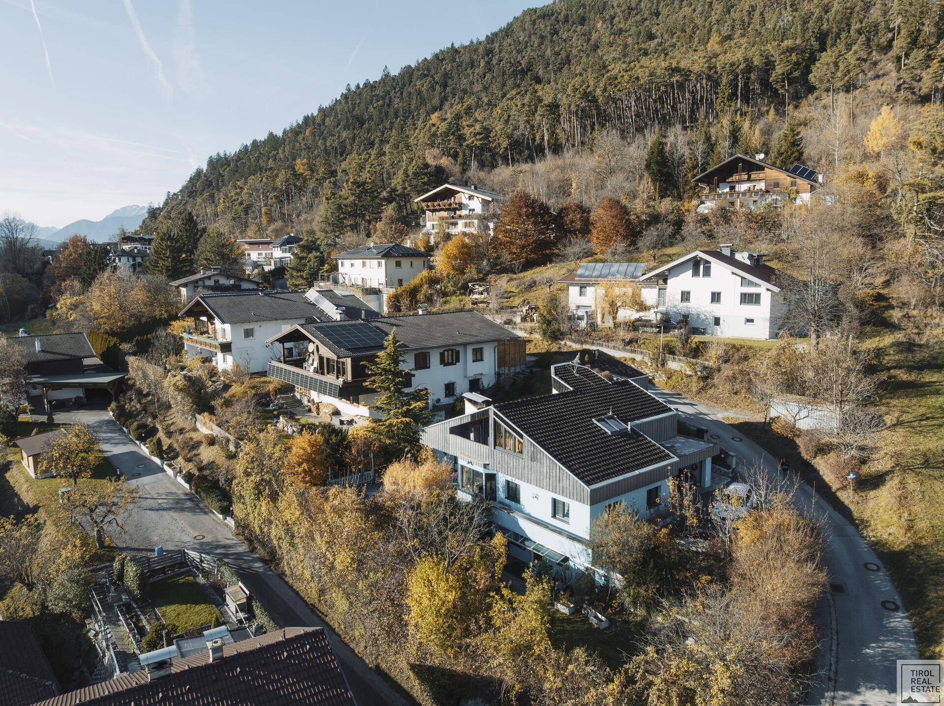 Luftaufnahme einer Wohnsiedlung in den Bergen mit mehreren Häusern.