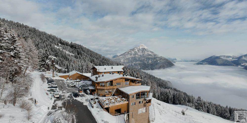 Winterliche Ansicht eines Gebäudekomplexes in den Bergen mit Nebel im Tal.