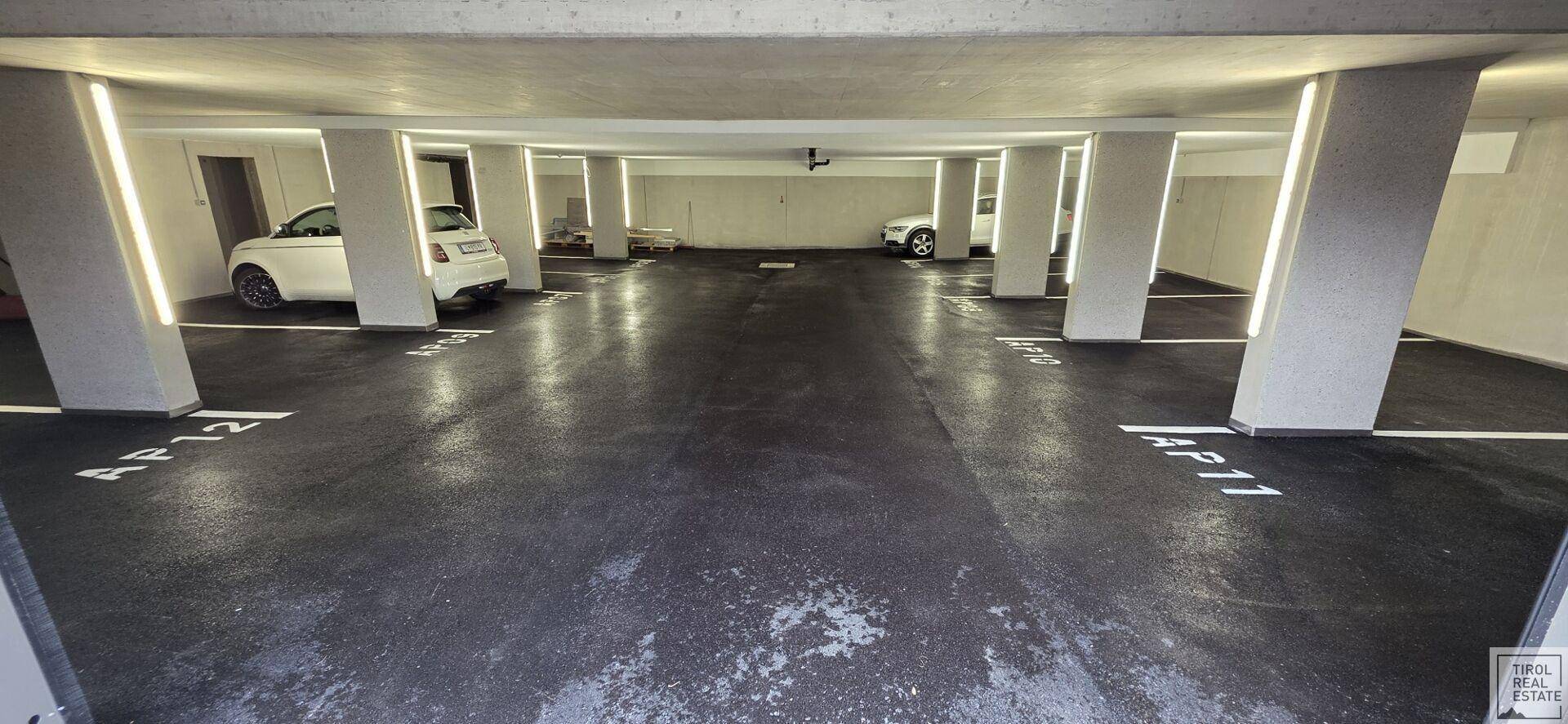 Tiefgarage mit mehreren Stellplätzen und moderner Beleuchtung.