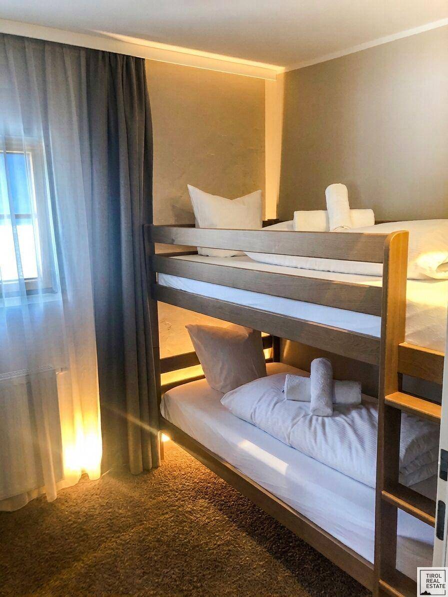 Gemütliches Schlafzimmer mit Etagenbett und Teppichboden, ideal für Kinder oder Gäste.
