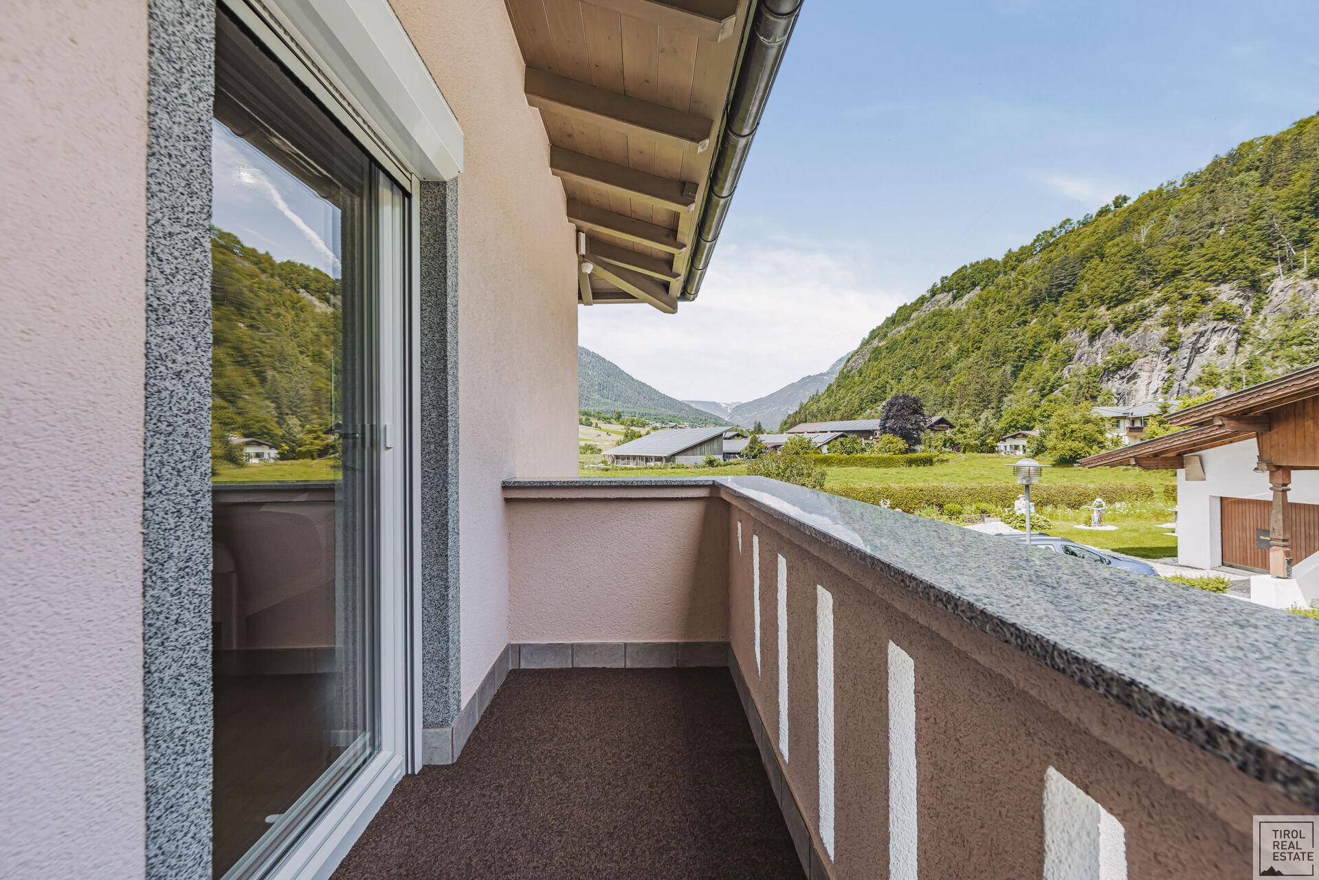 Balkon mit Panoramablick auf die umliegenden Berge und das Tal.