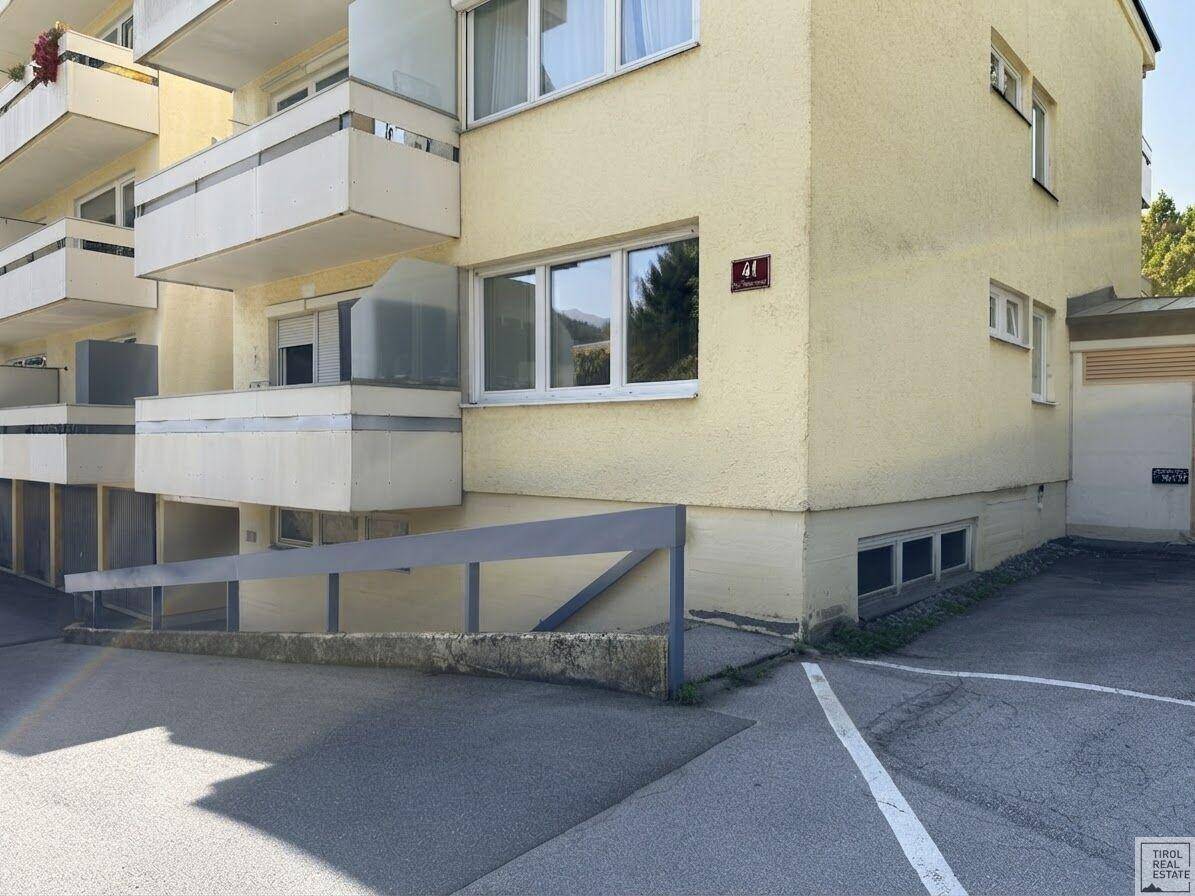 Ansicht des Gebäudes mit Balkonen, Zufahrt und einer Rampe für Barrierefreiheit.