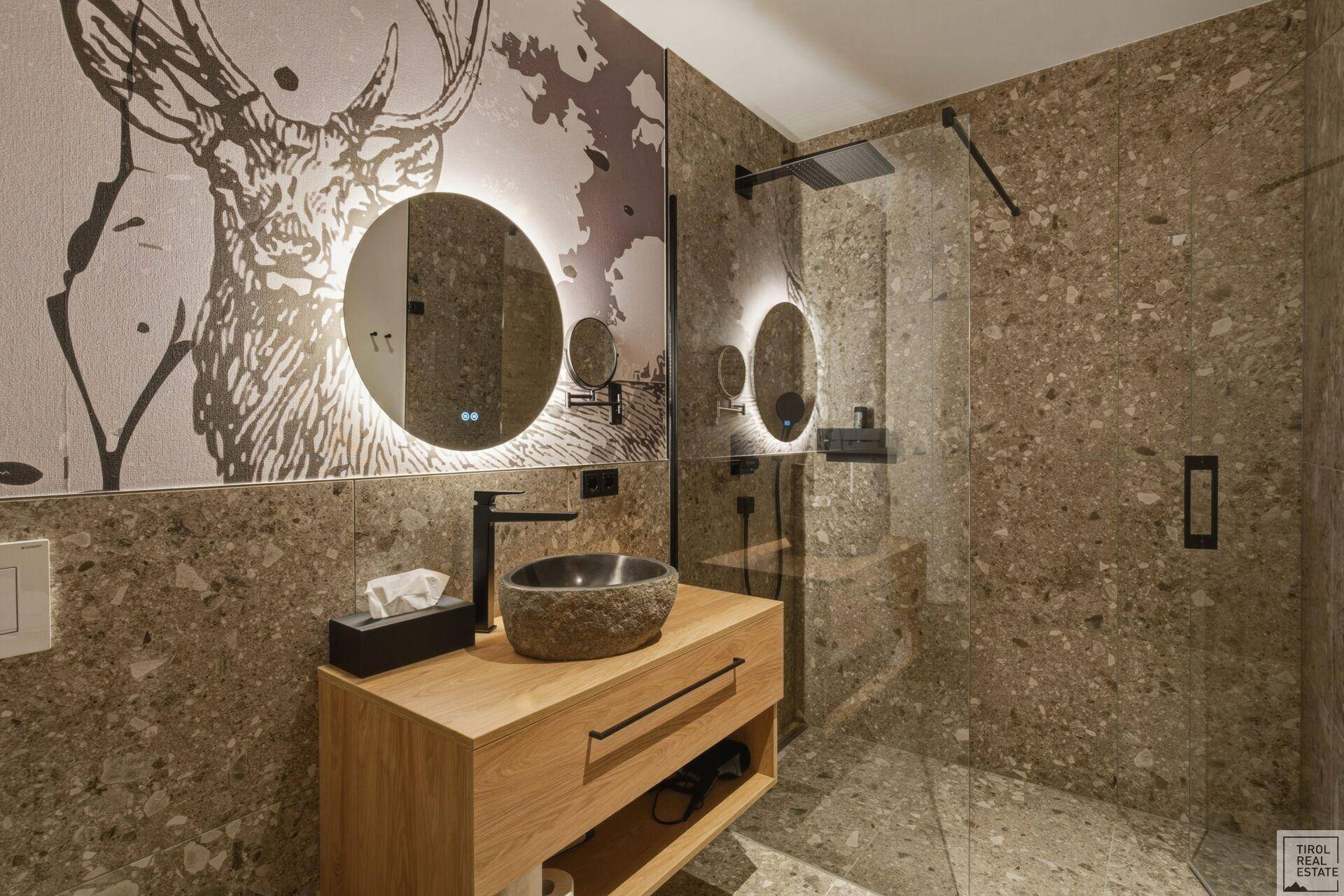 Stilvolles Badezimmer mit großer begehbarer Dusche und modernem Steinwaschbecken.
