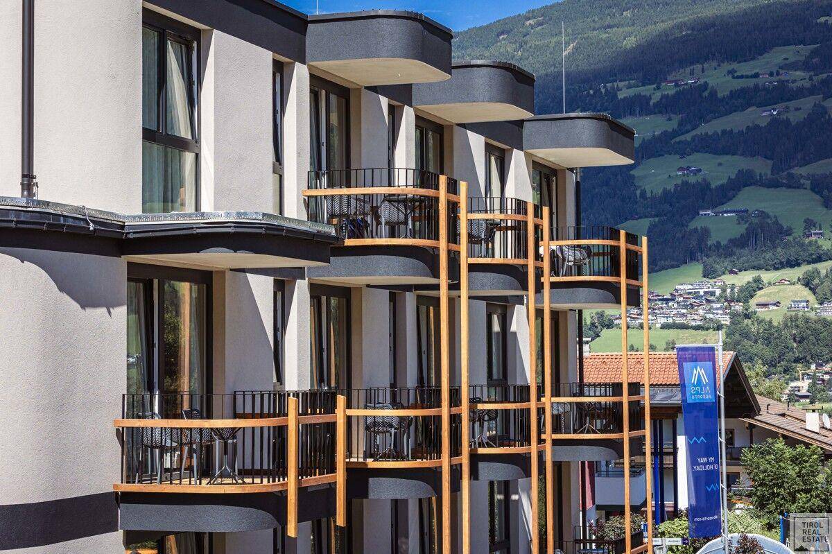 Detailansicht der Balkone eines modernen Gebäudes mit Bergblick und Sitzgelegenheiten.