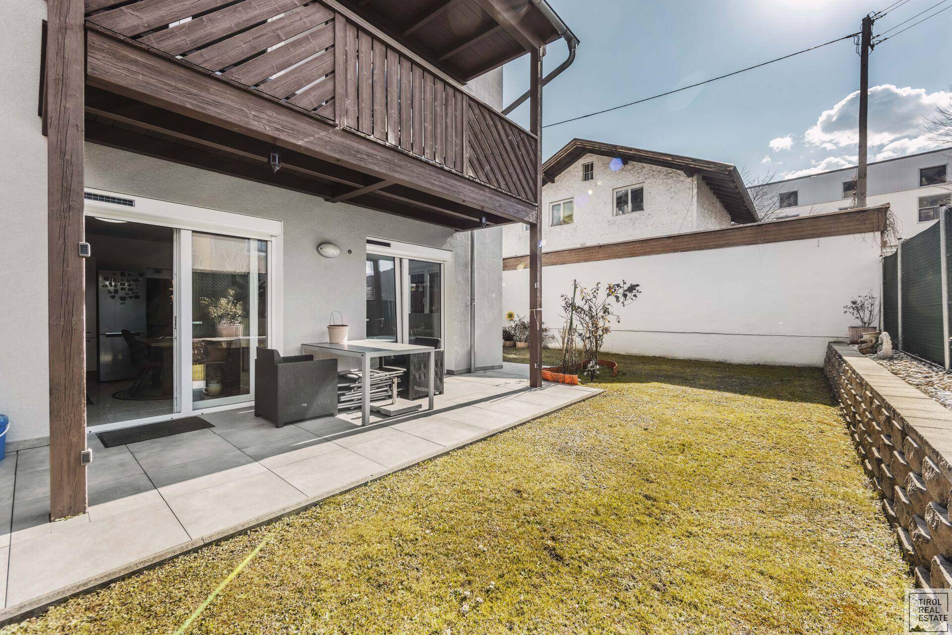 Sonniger Terrassenbereich mit Sitzgelegenheiten und Zugang zum privaten Garten.