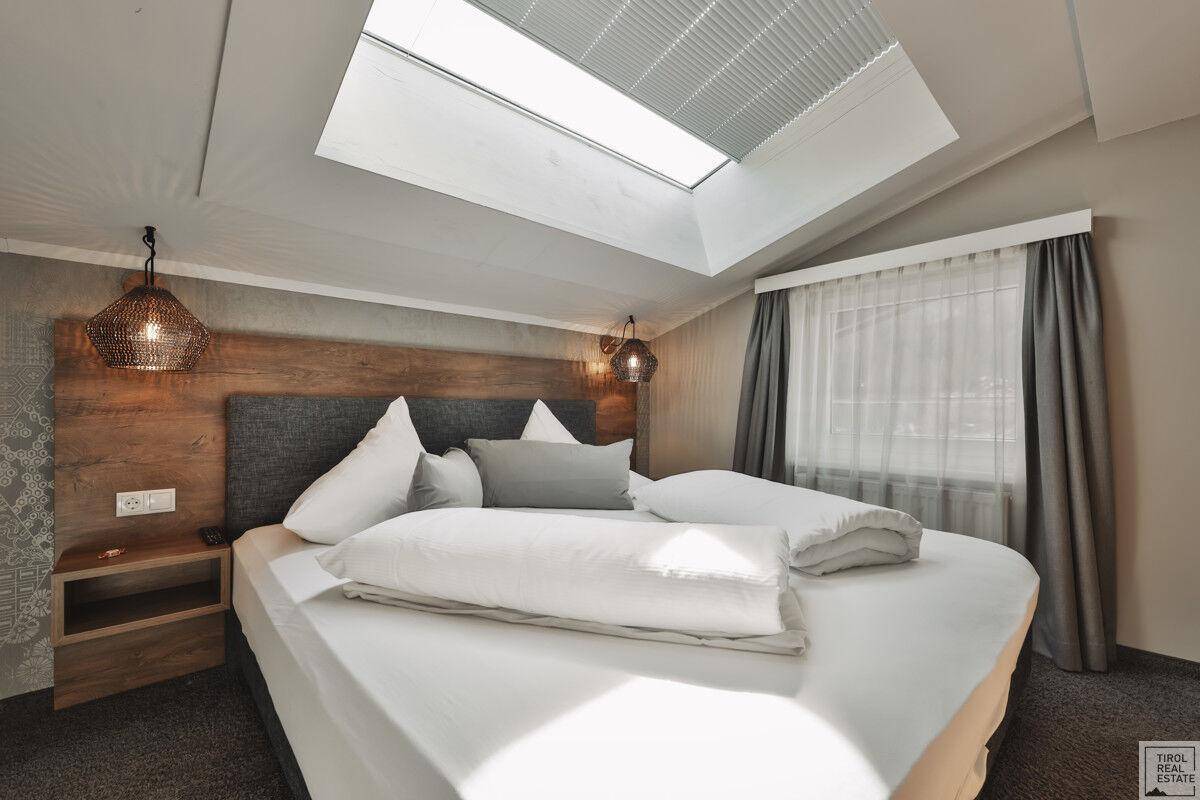 Schlafzimmer im Dachgeschoss mit Doppelbett, Dachfenster und gemütlicher Atmosphäre unter der Schräge.