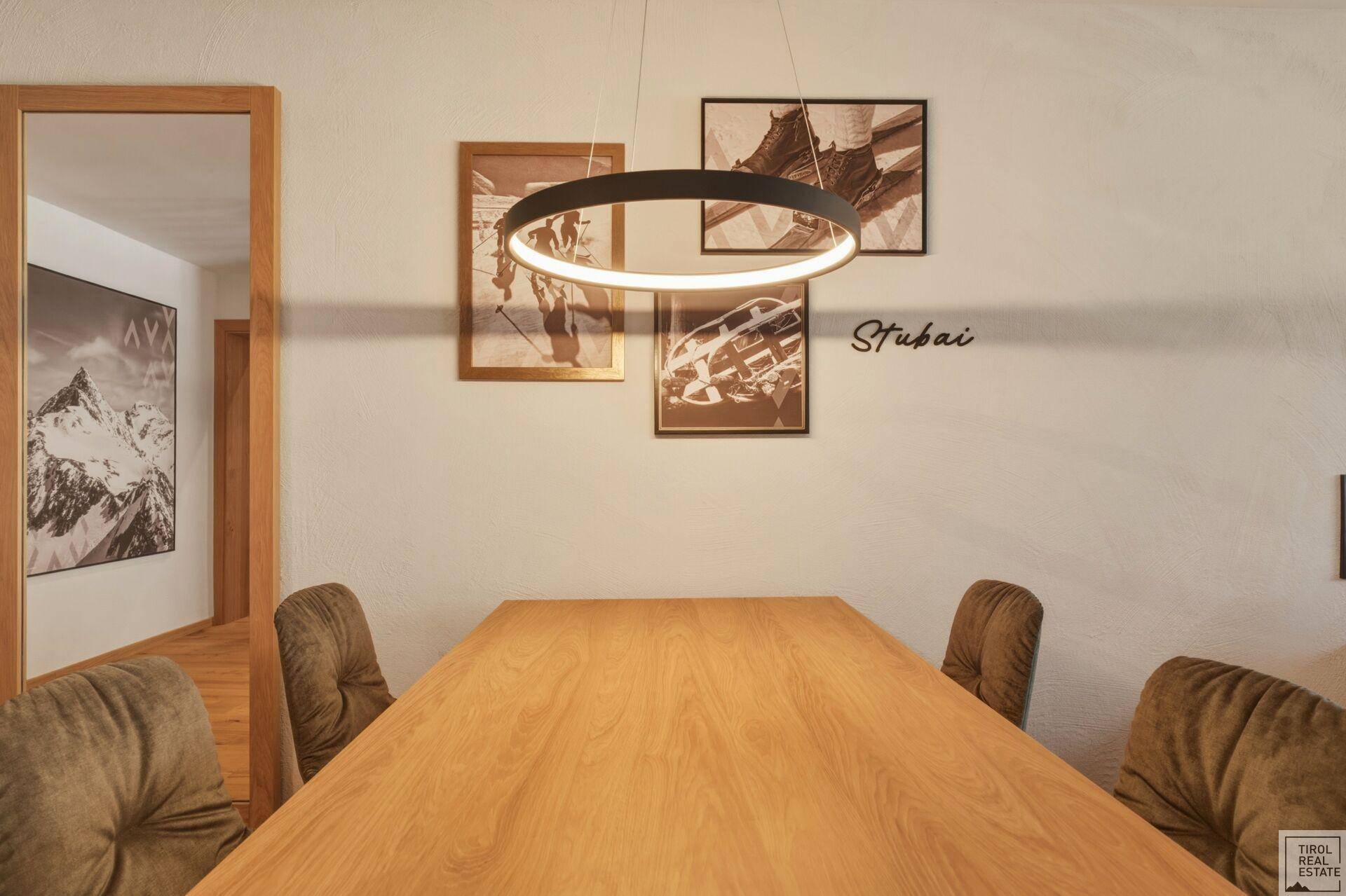 Heller Essbereich mit Holztisch, modernen Stühlen und dekorativen Wandbildern.