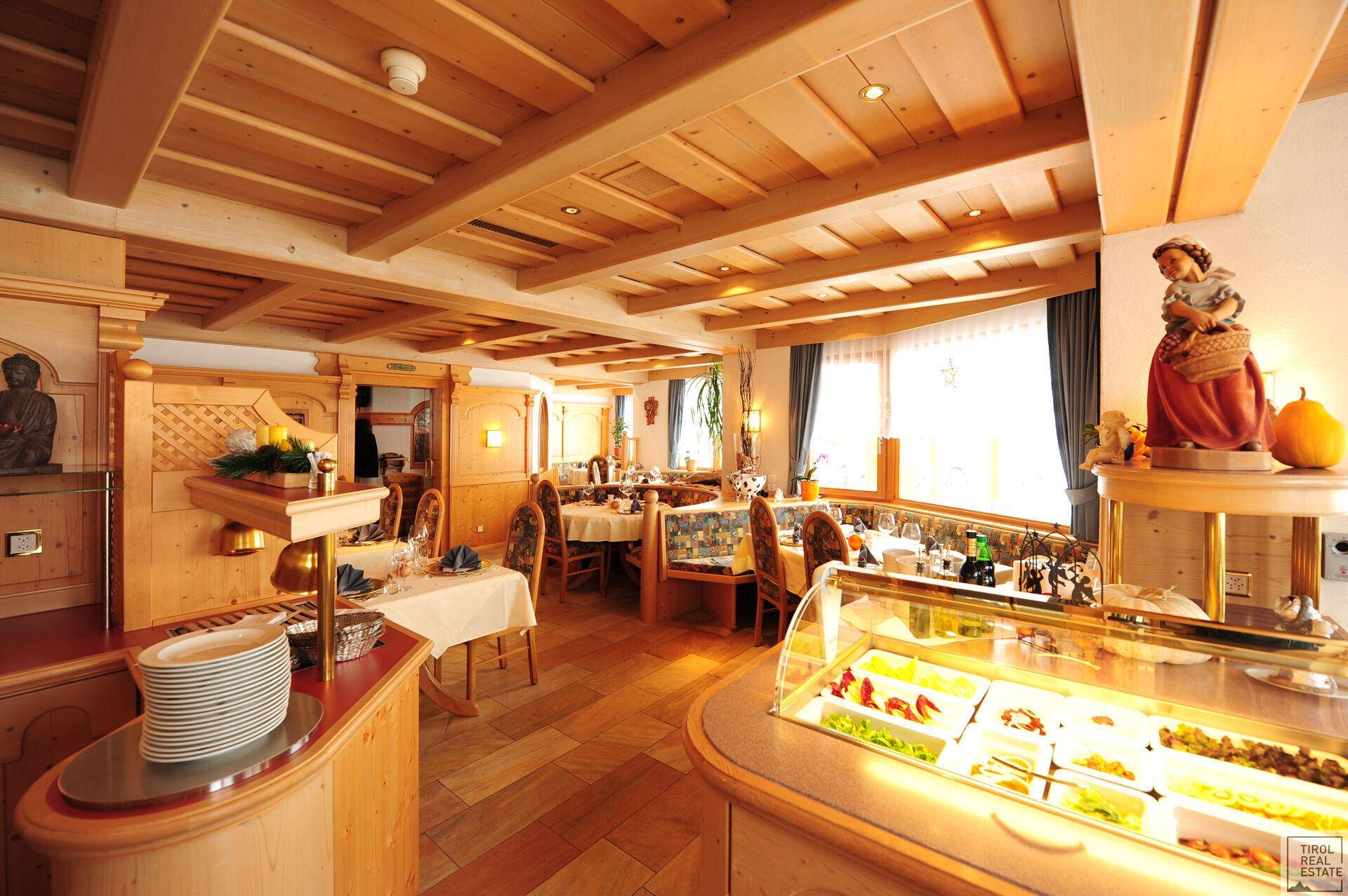 Speisesaal mit einem Buffetbereich, Holzbalkendecke und traditioneller Einrichtung, ideal für Mahlzeiten.